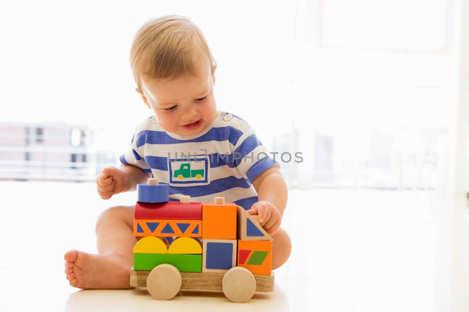 Baby indoors playing with truck
