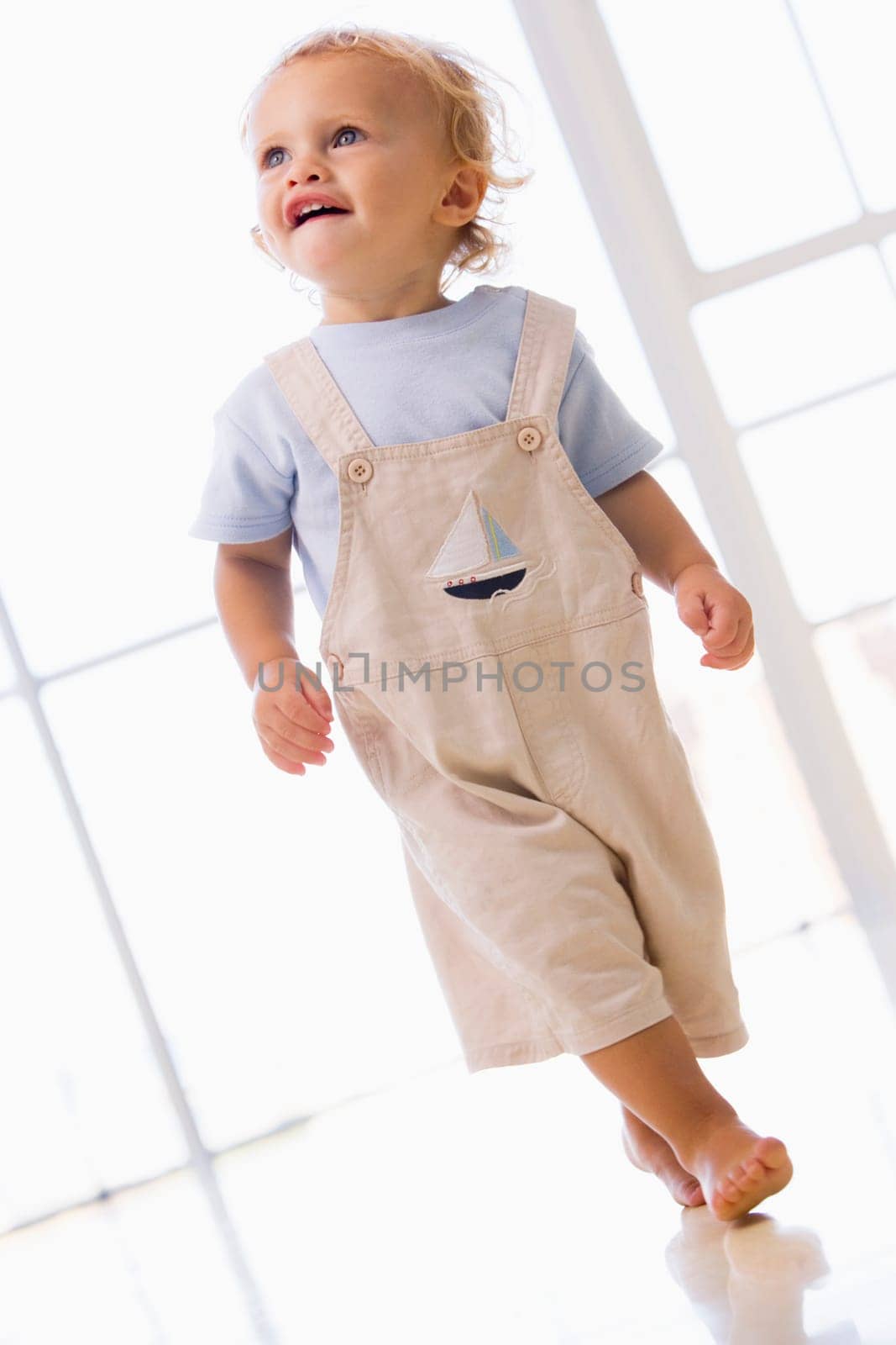 Young boy walking indoors smiling