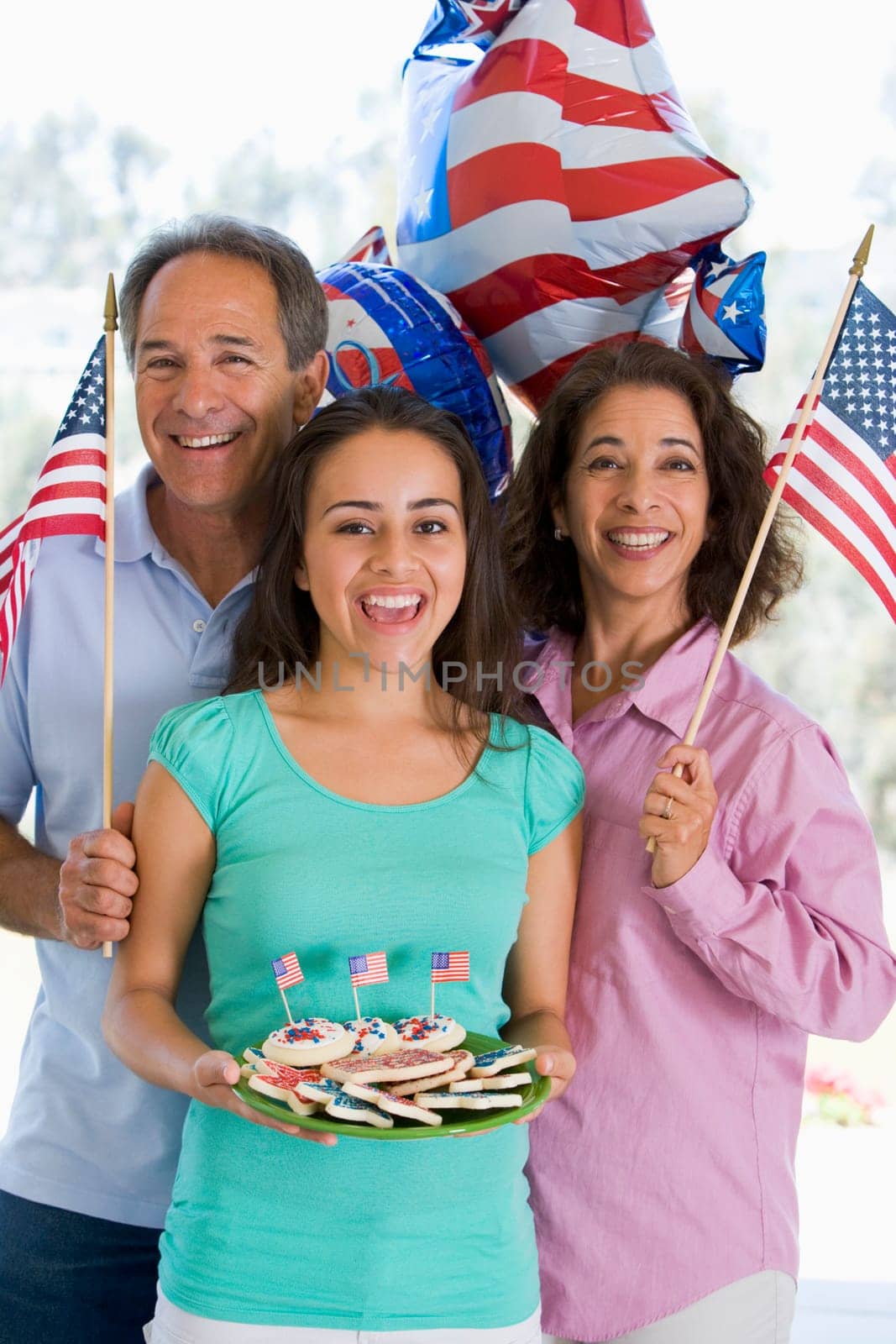 Family outdoors on fourth of July with flags and cookies smiling