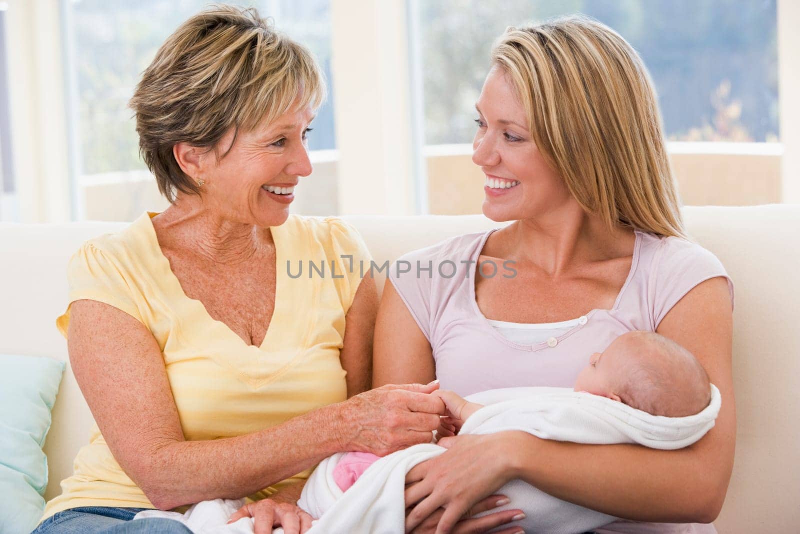 Grandmother and mother in living room with baby smiling
