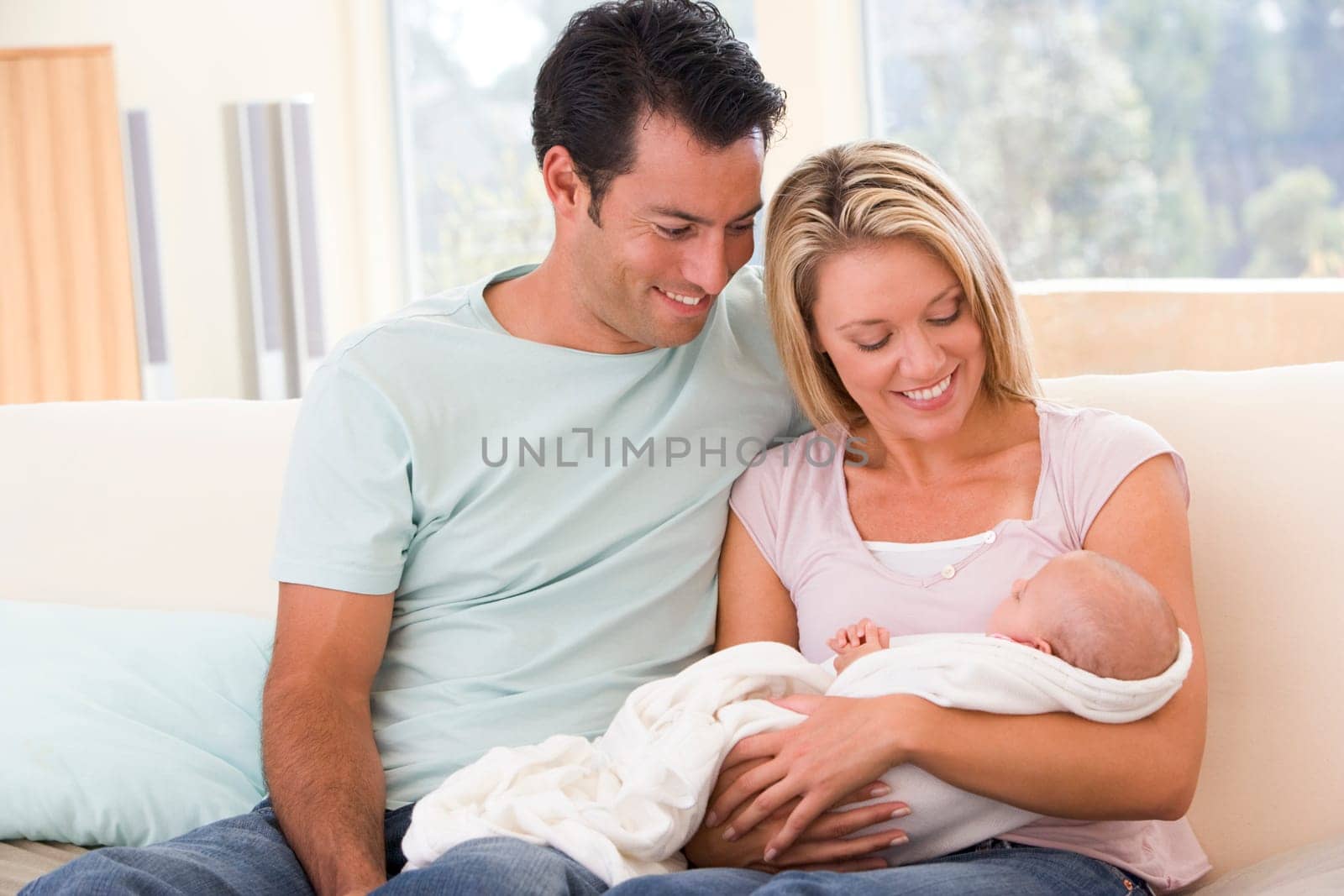 Couple in living room with baby smiling