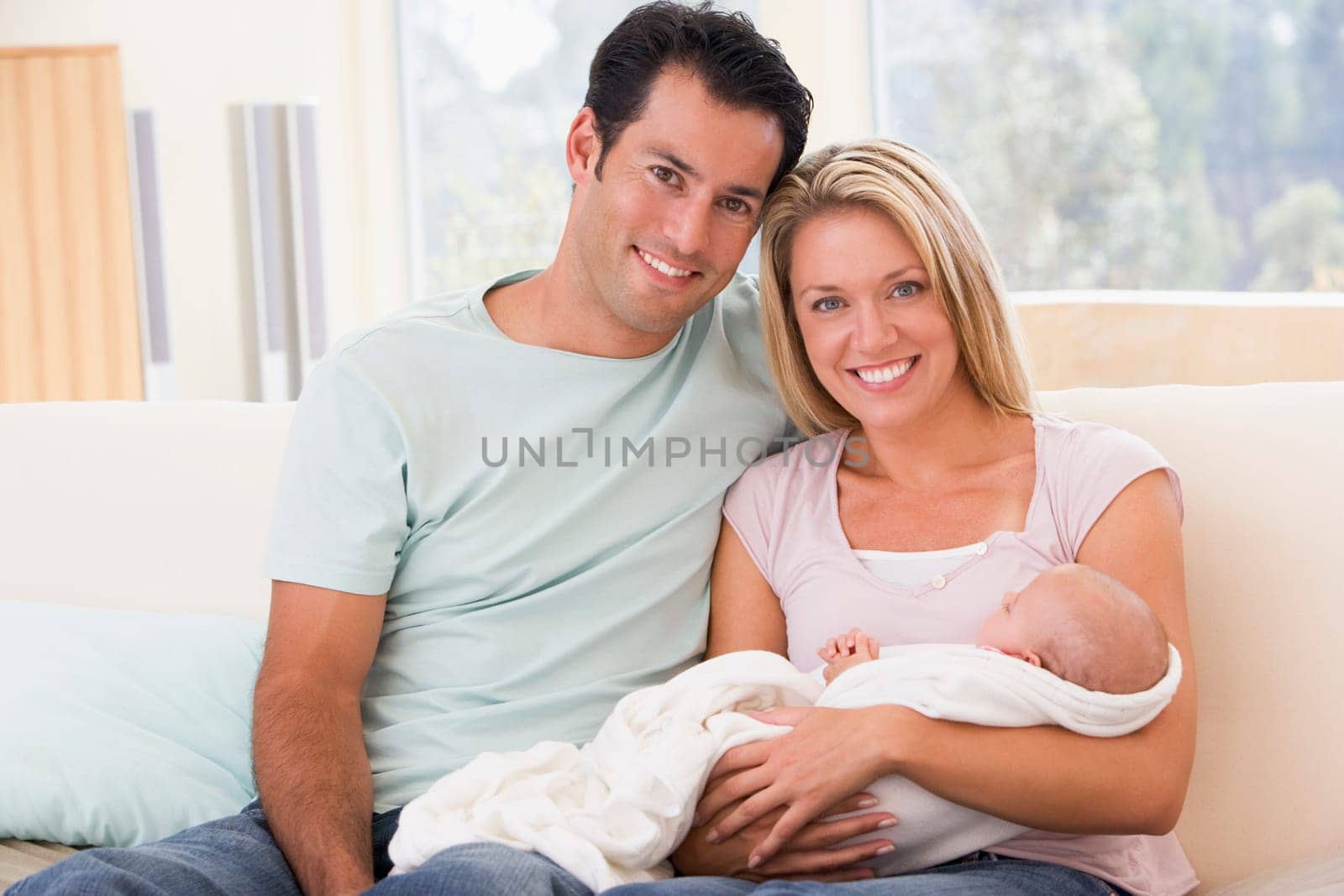 Couple in living room with baby smiling