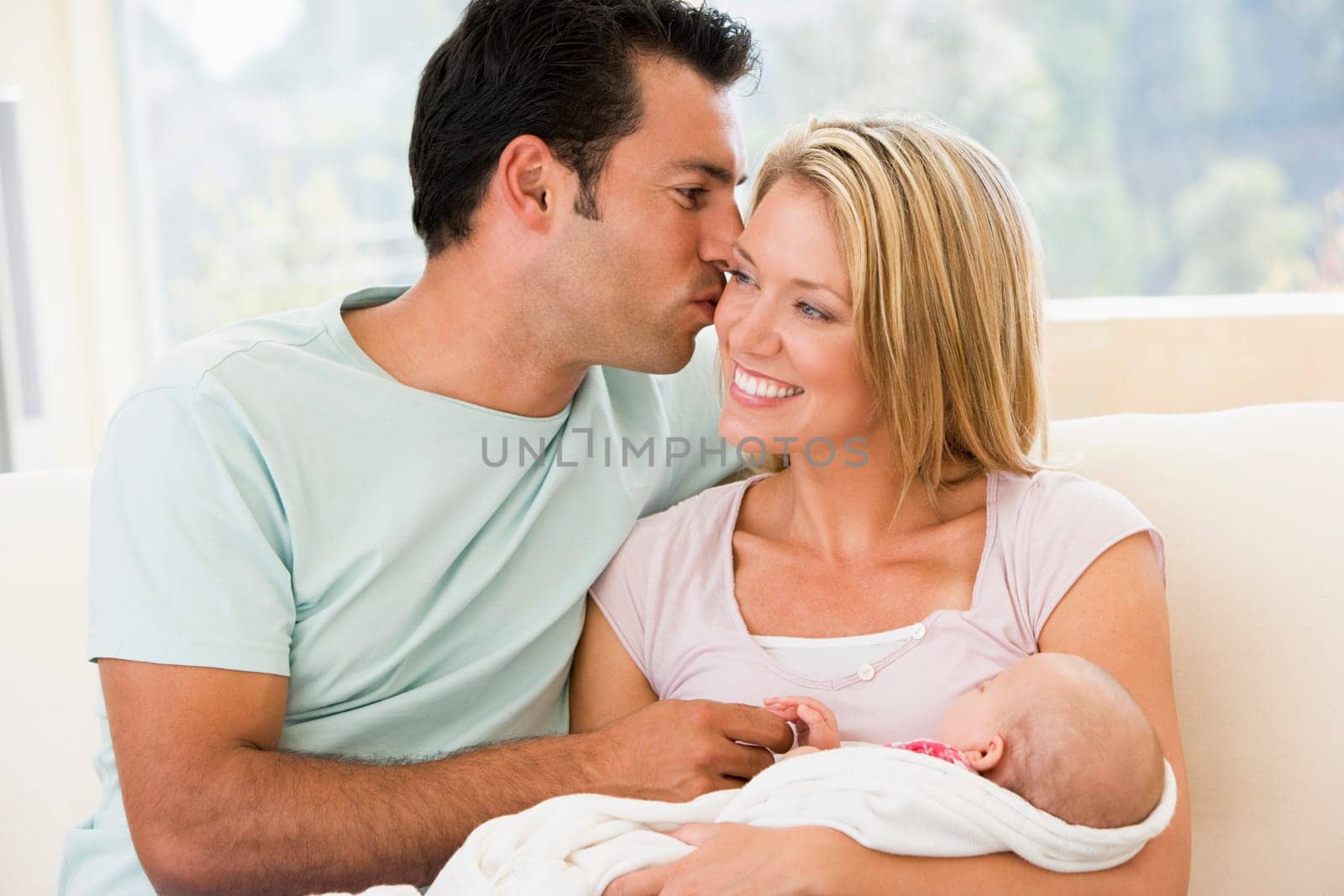 Couple in living room with baby smiling