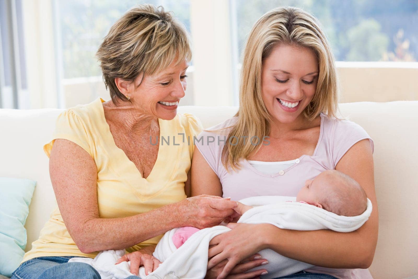 Grandmother and mother in living room with baby smiling
