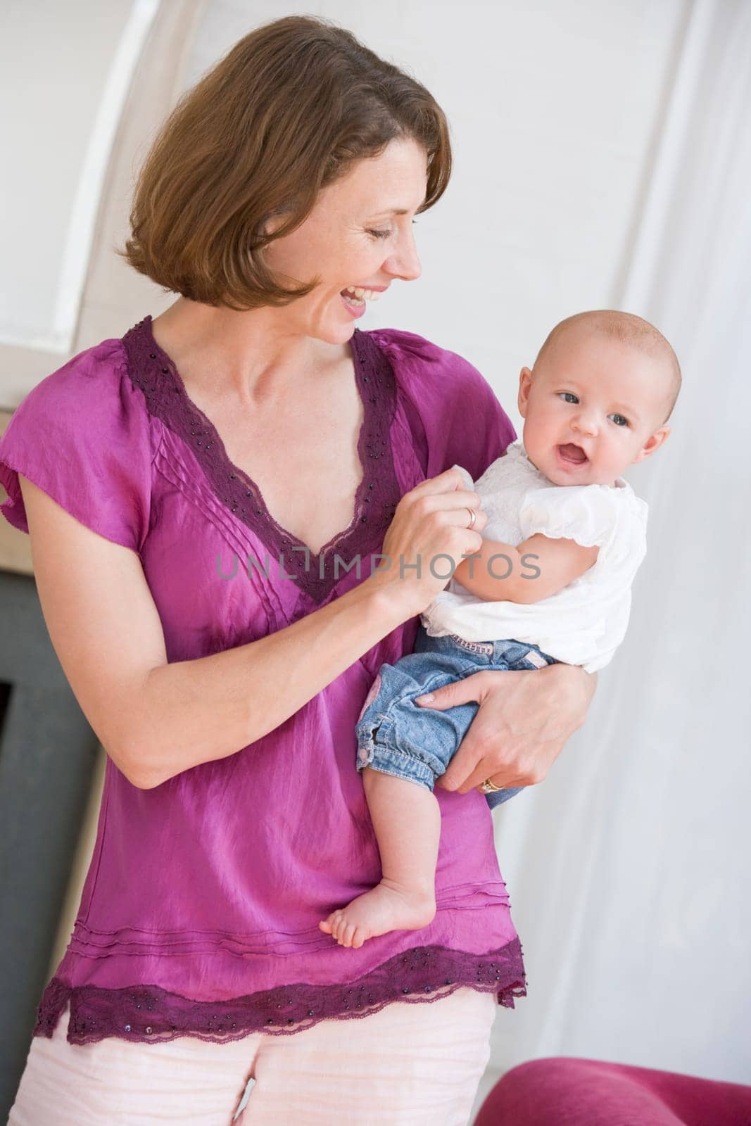 Mother in living room holding baby smiling