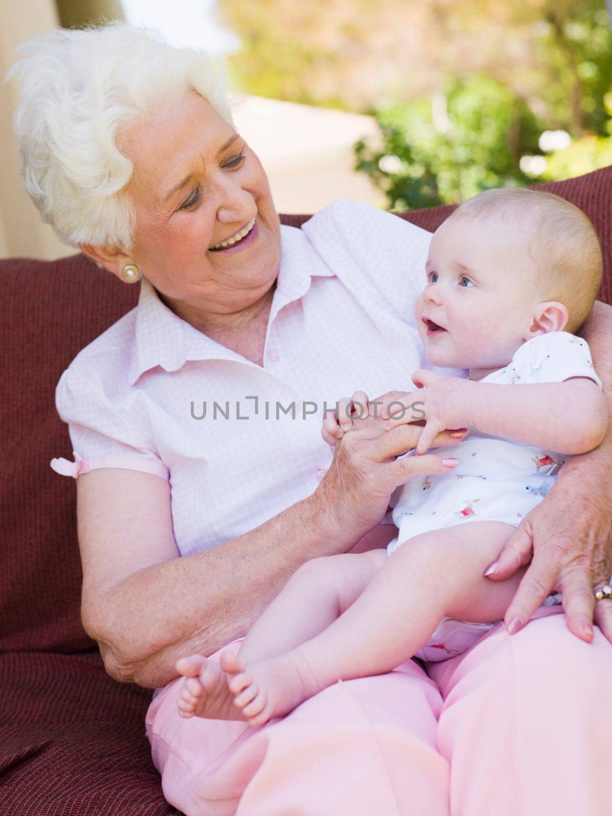 Grandmother outdoors on patio with baby smiling