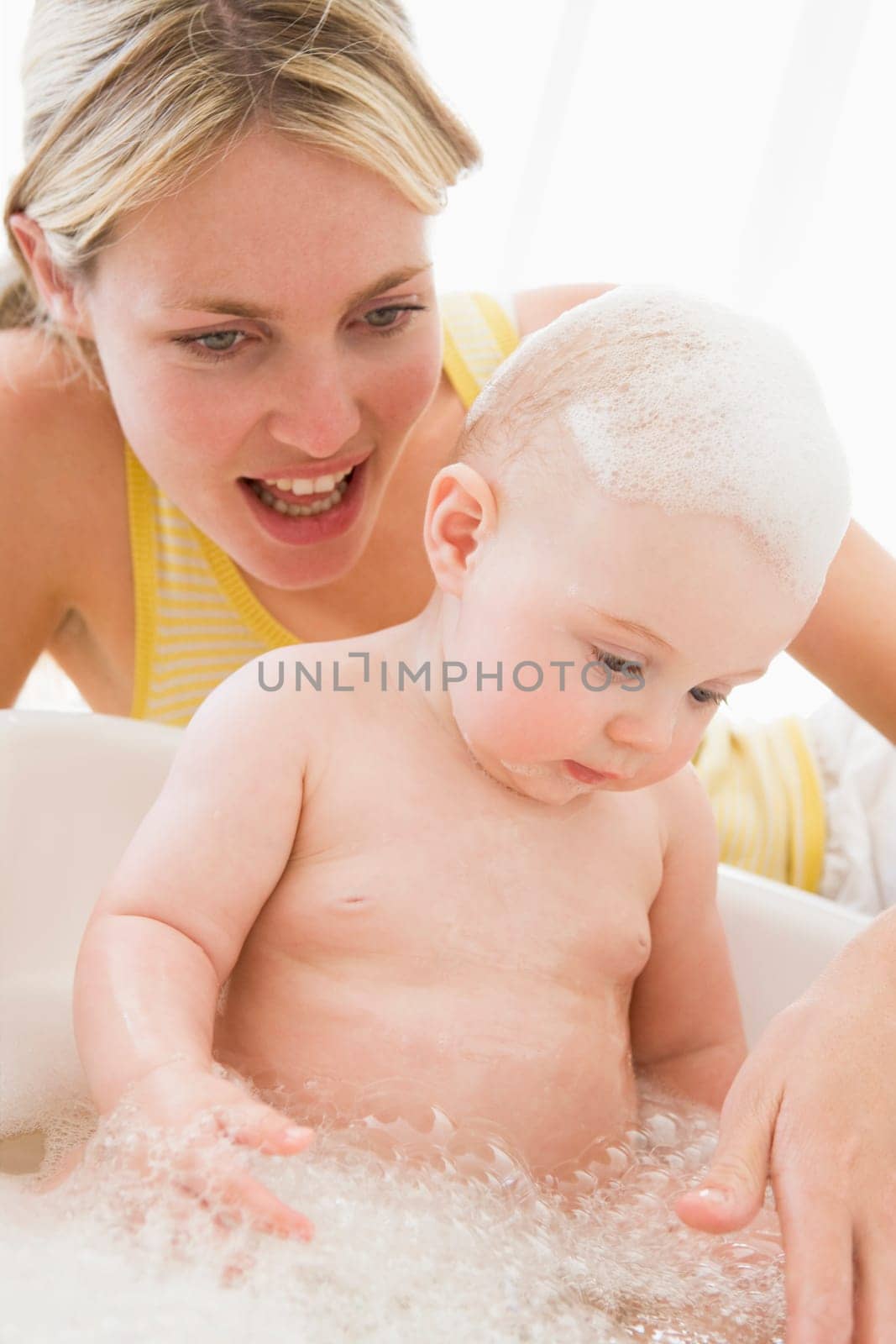 Mother giving baby bubble bath smiling