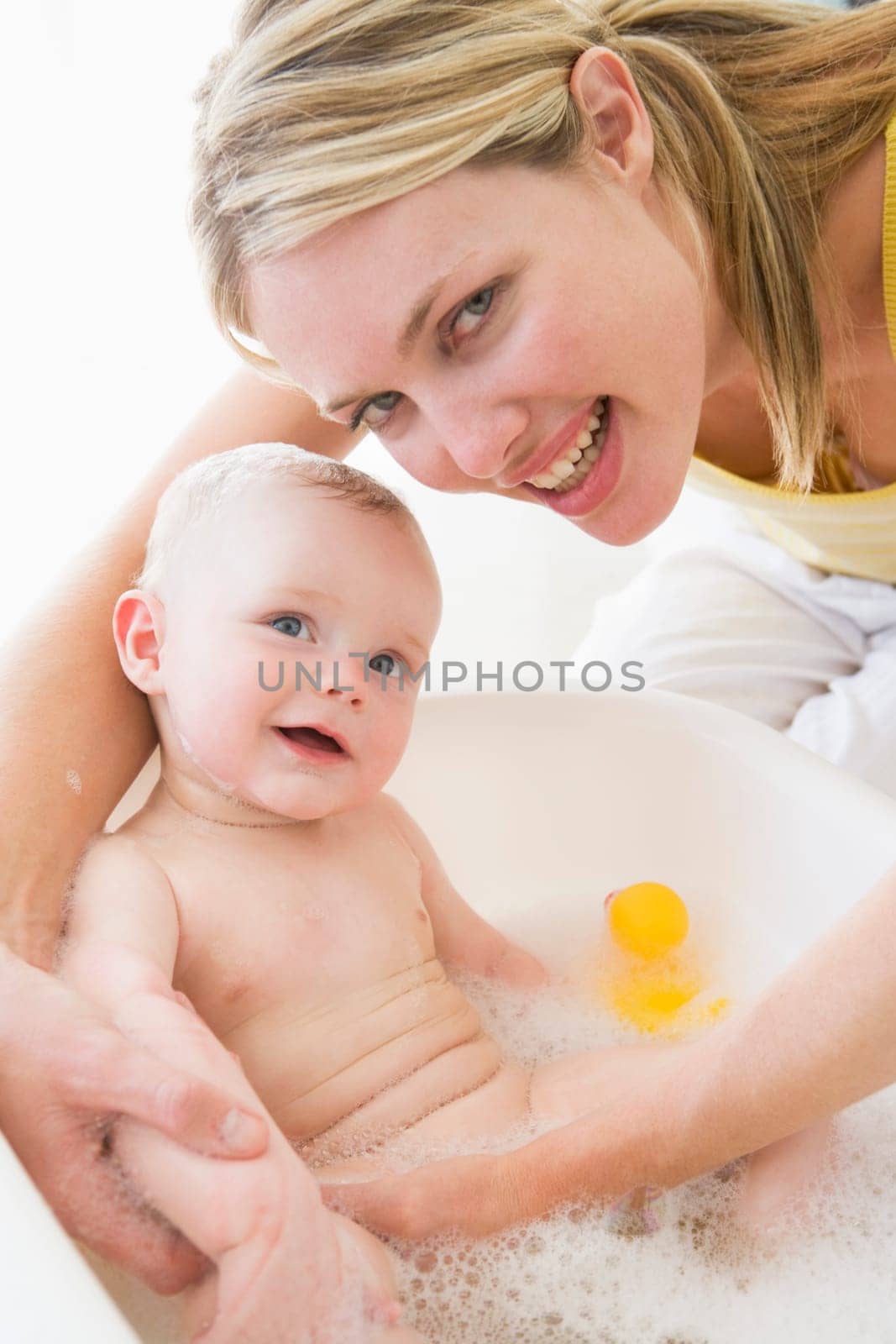 Mother giving baby bubble bath smiling