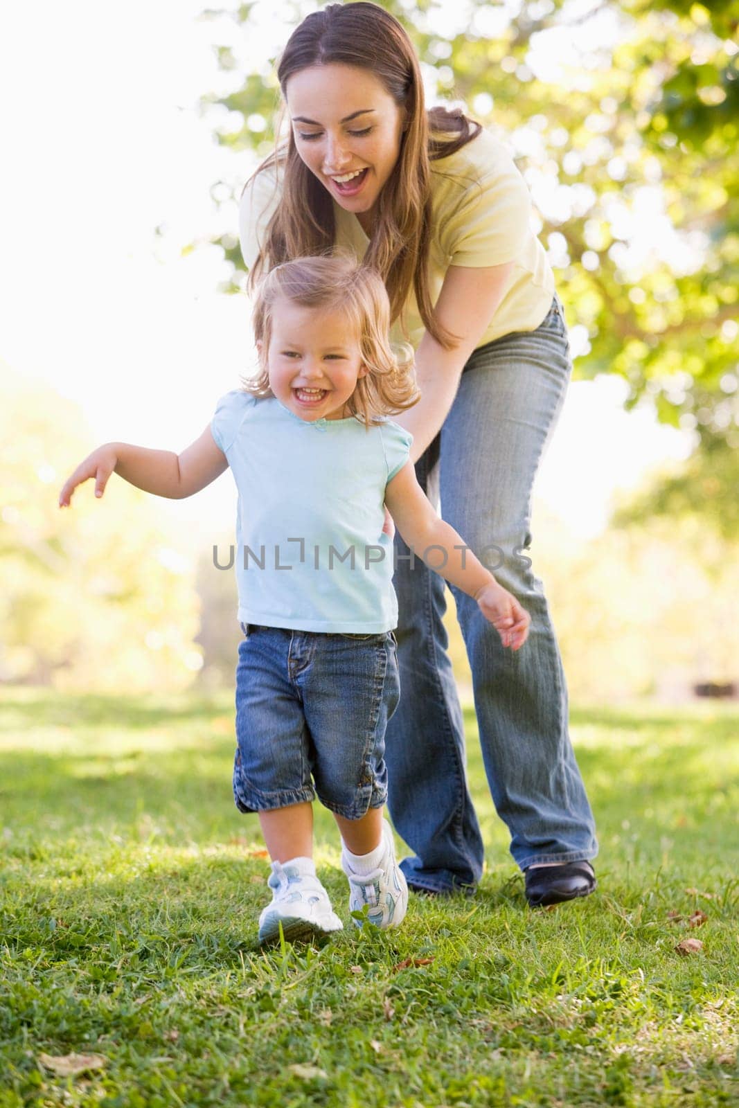 Mother and daughter playing outdoors smiling