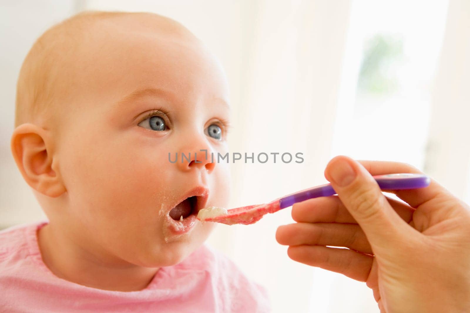 Mother feeding baby food to baby