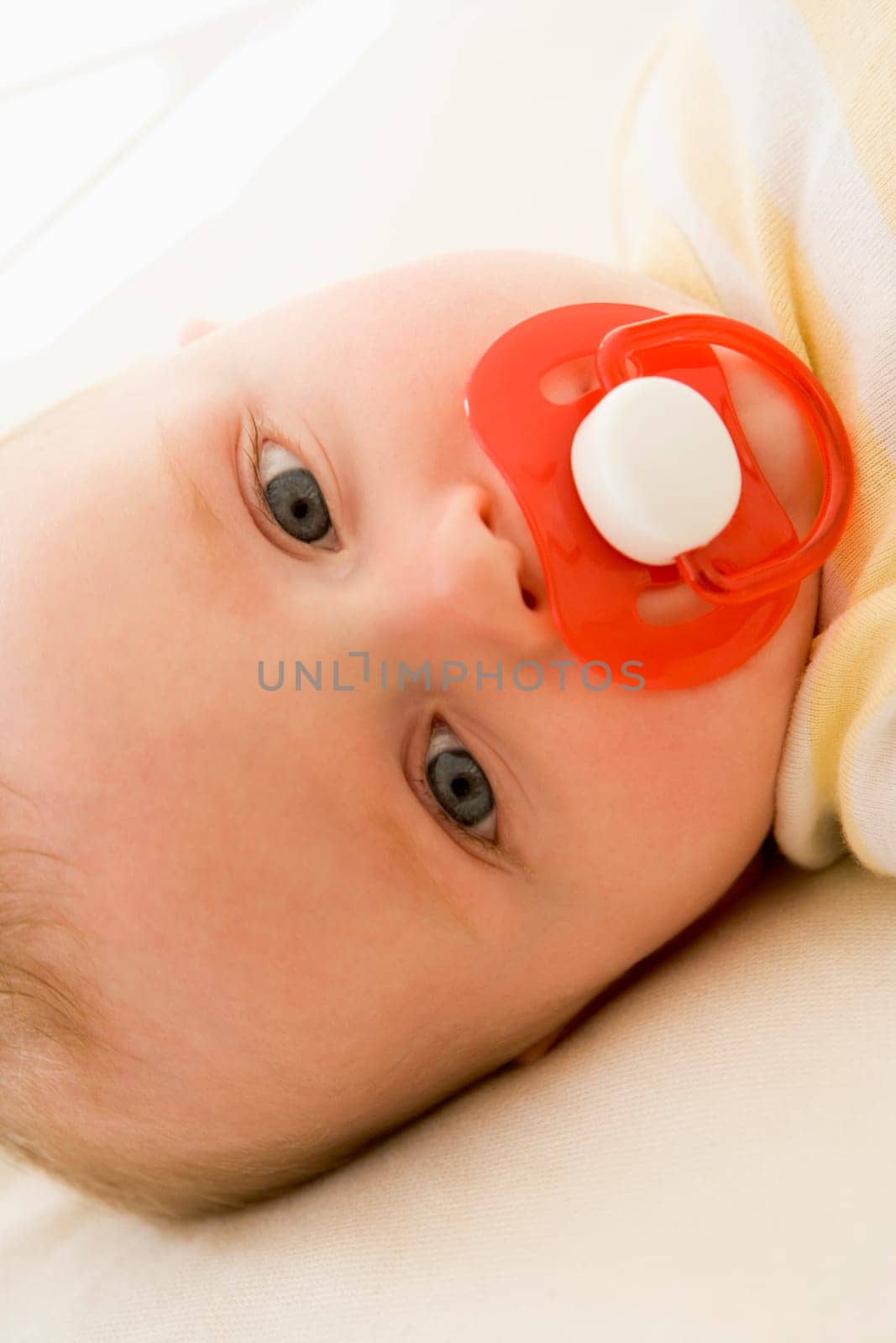 Baby lying indoors with soother