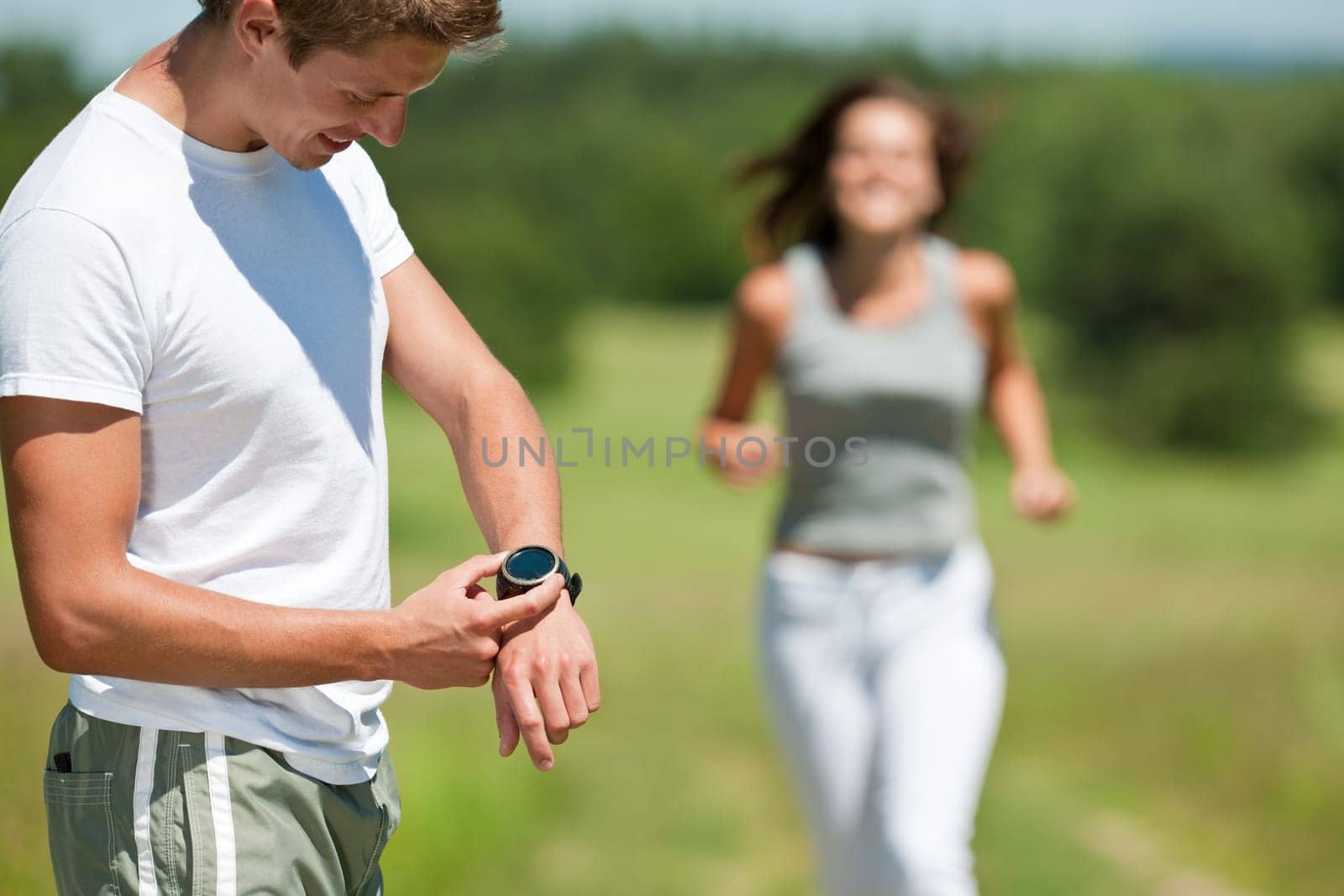 Young man and woman jogging in meadow