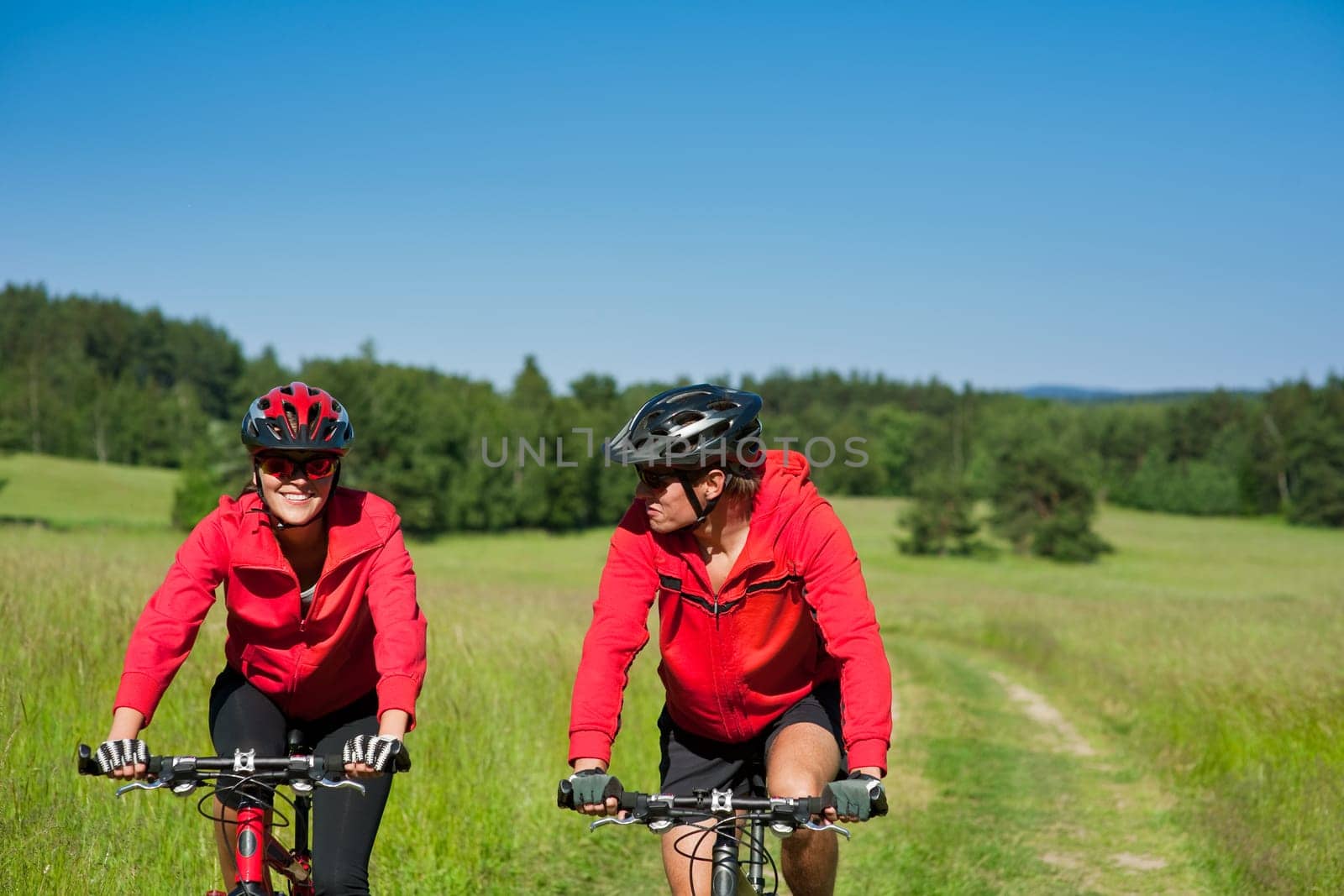 Summer - young man woman couple ride mountain bike in nature