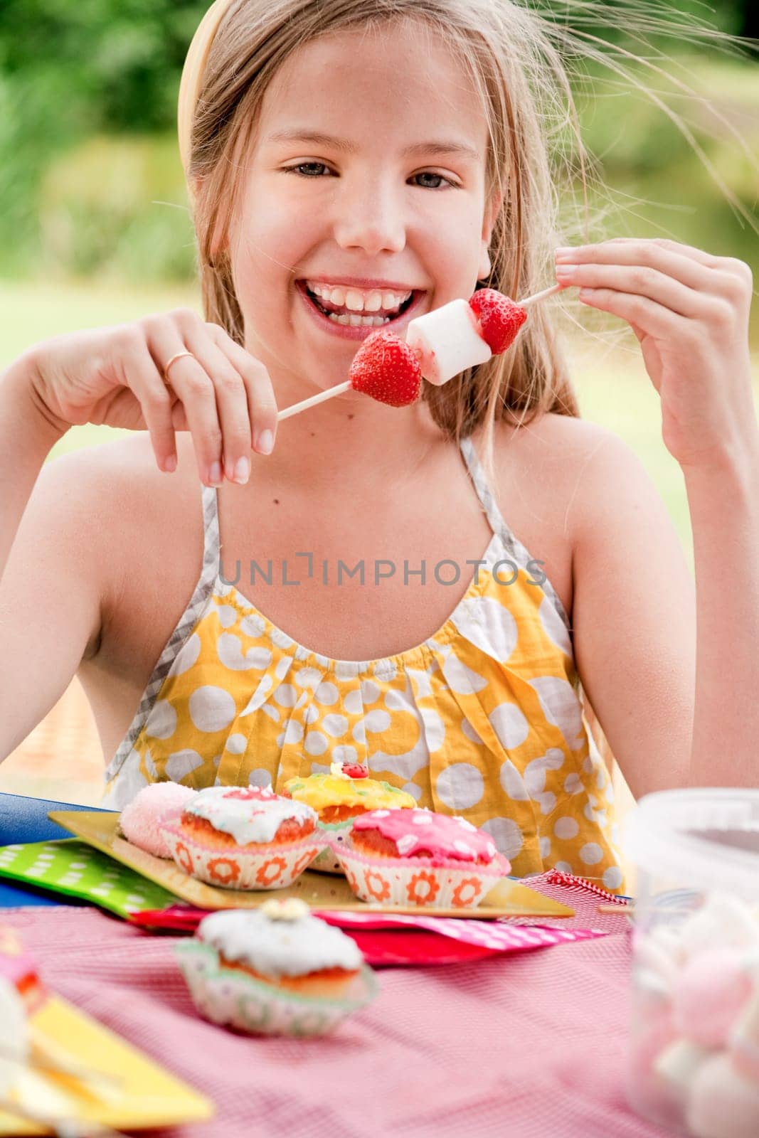 Smiling girl and a stick full of marshma