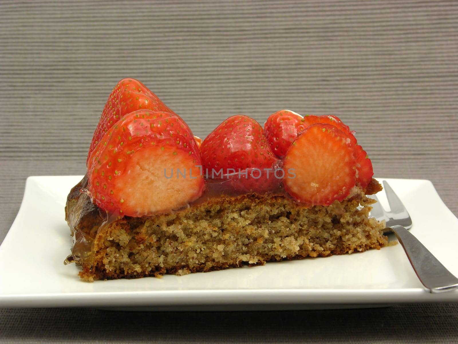 A piece of strawberry cake on white plate