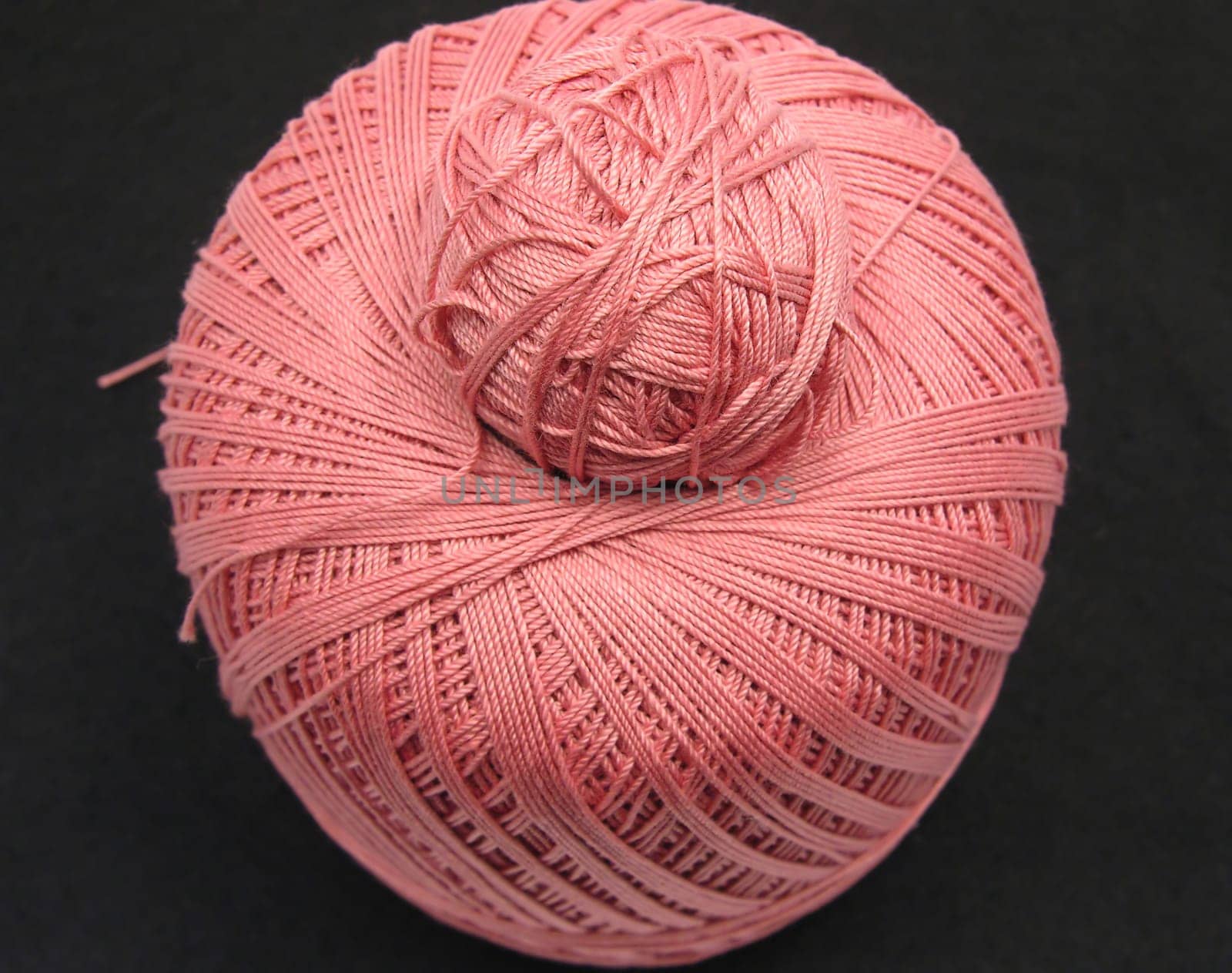 Pink wool ball stacked on black background
