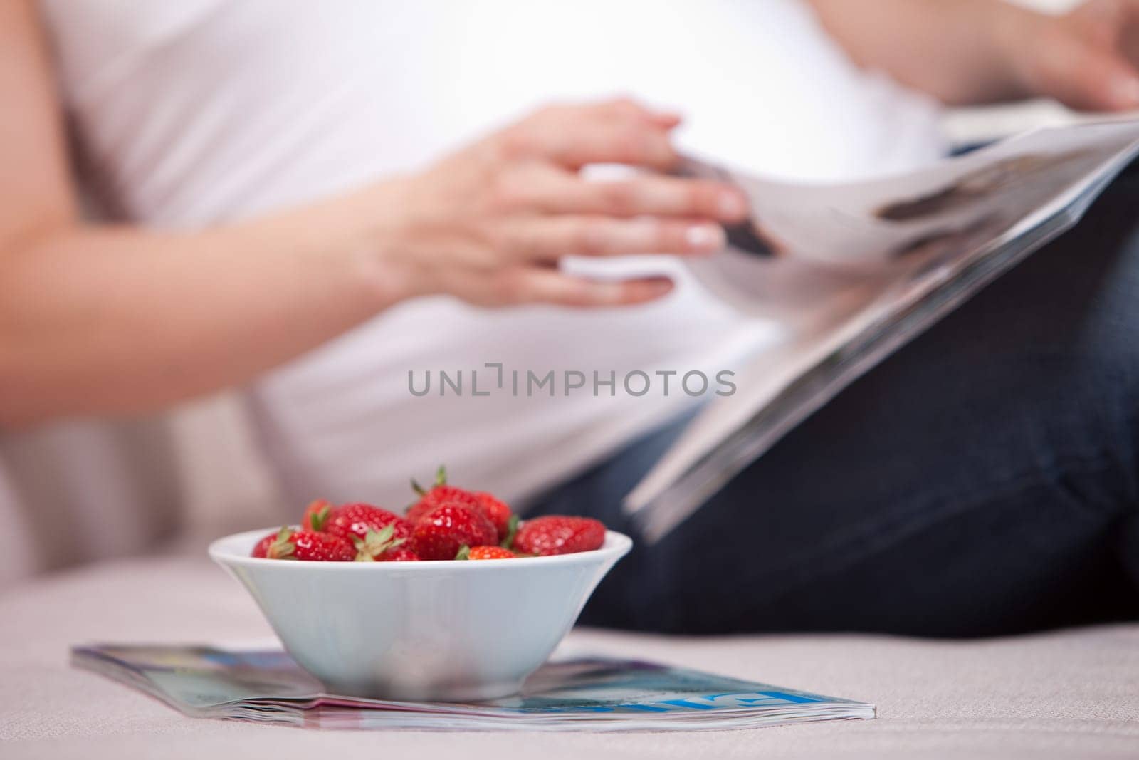 Woman with magazines and strawberries