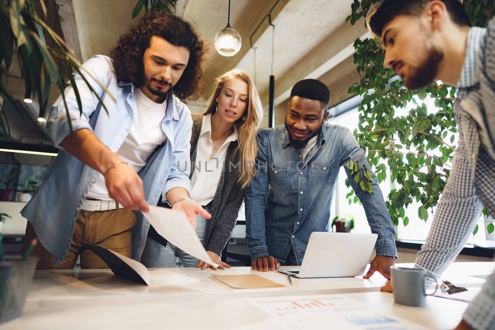 Smiling multiracial coworkers working together at office meeting, have a discussion, teamwork concept