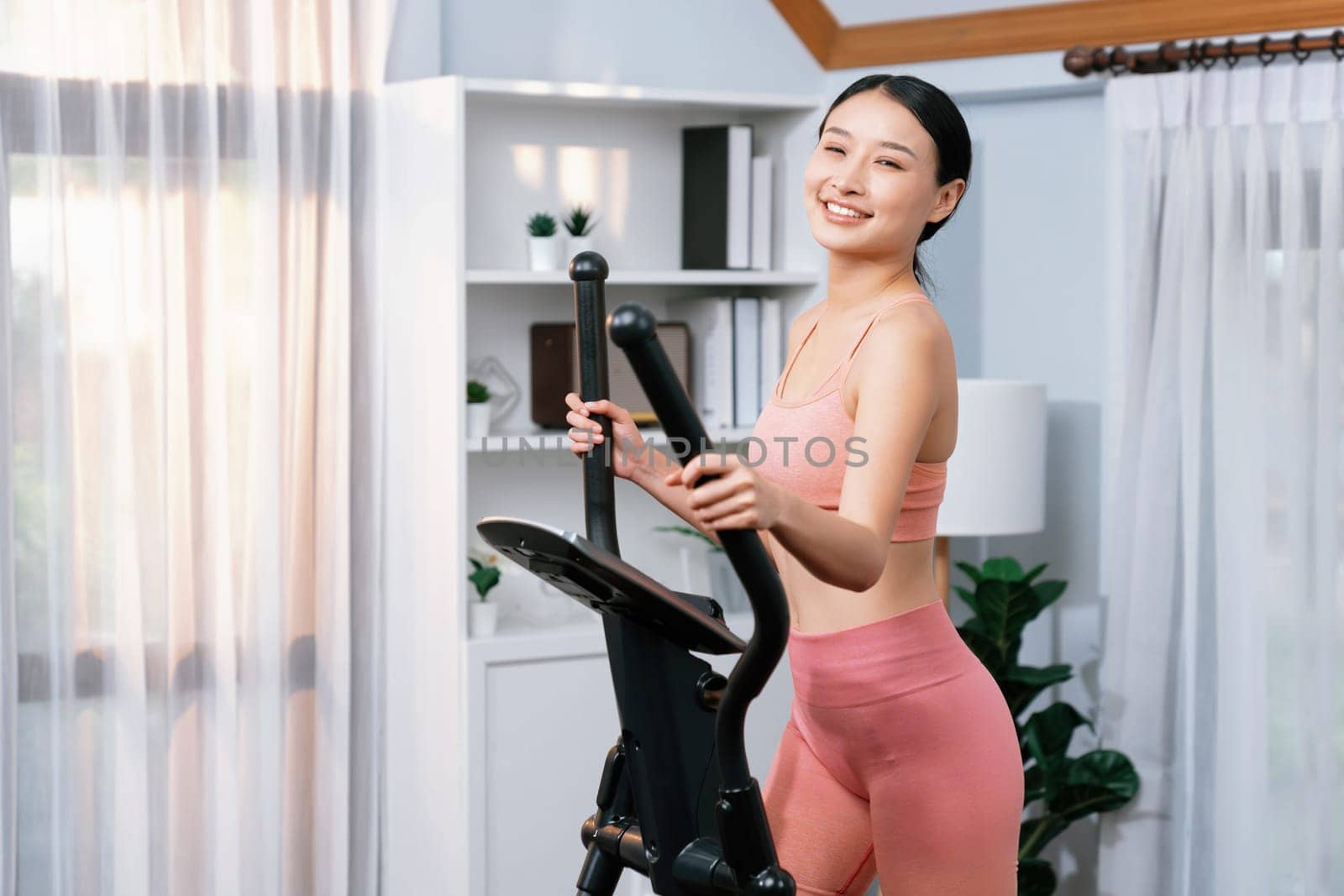 Energetic and strong athletic asian woman running on machine. Vigorous by biancoblue