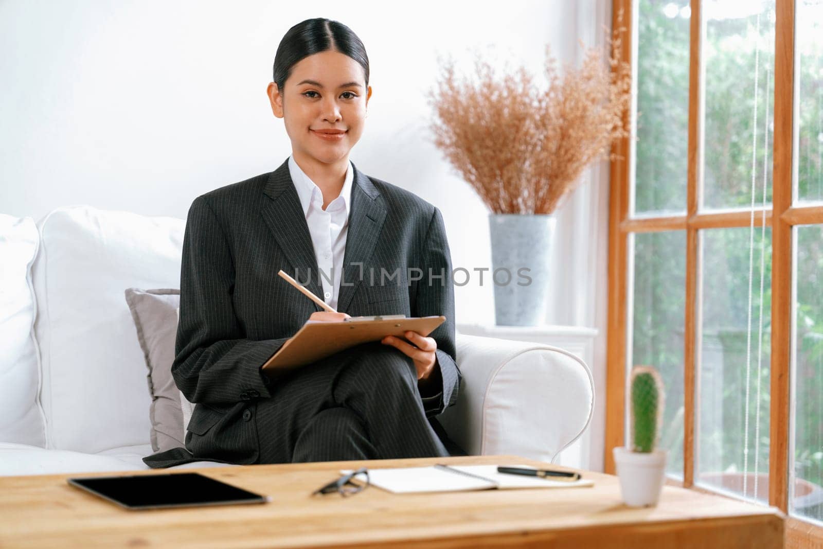 Psychologist woman in clinic office professional portrait with friendly smile feeling inviting for patient to visit the psychologist. The experienced and confident psychologist is uttermost specialist