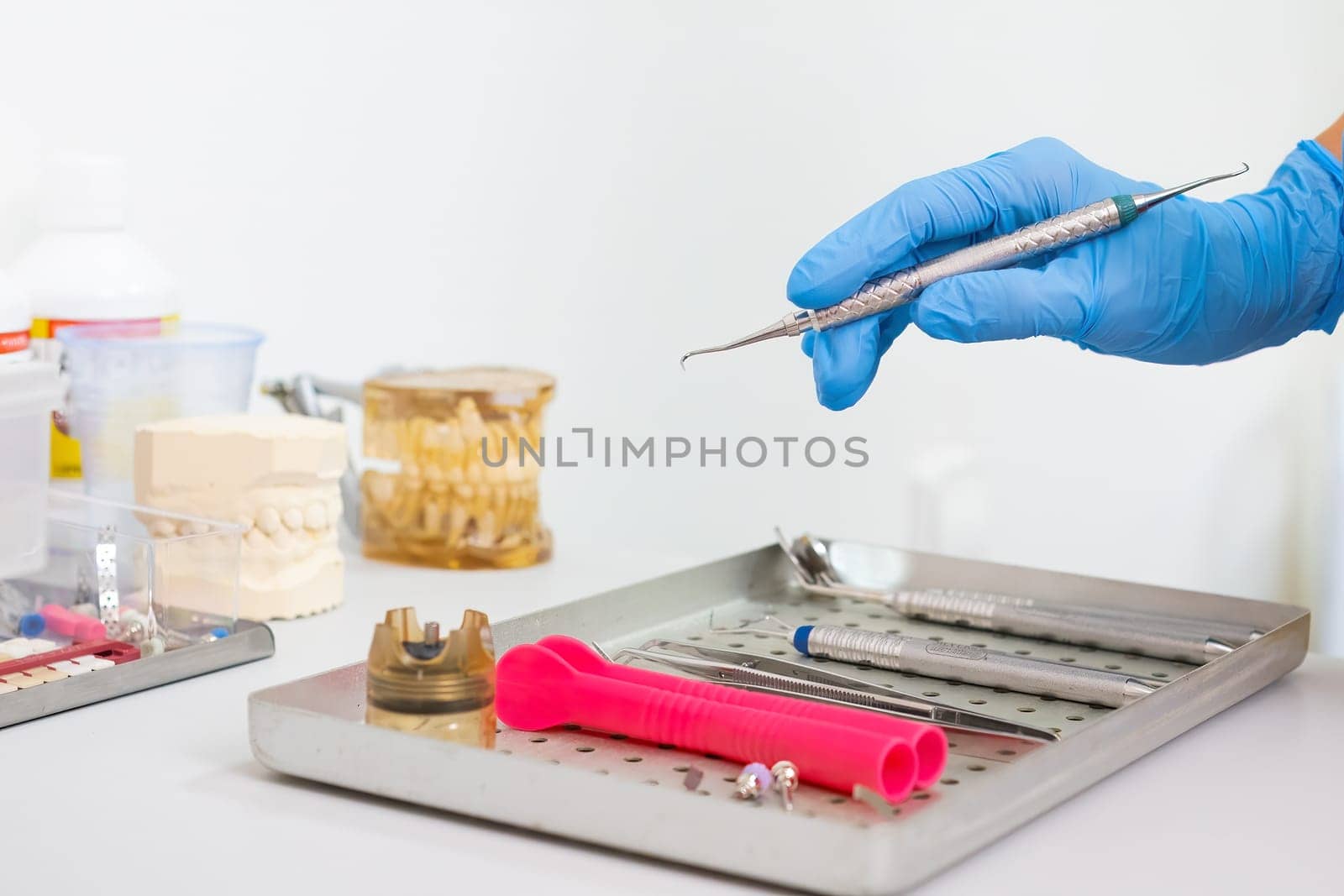 The dentists hook is being held by a doctor in a dental office for teeth care.