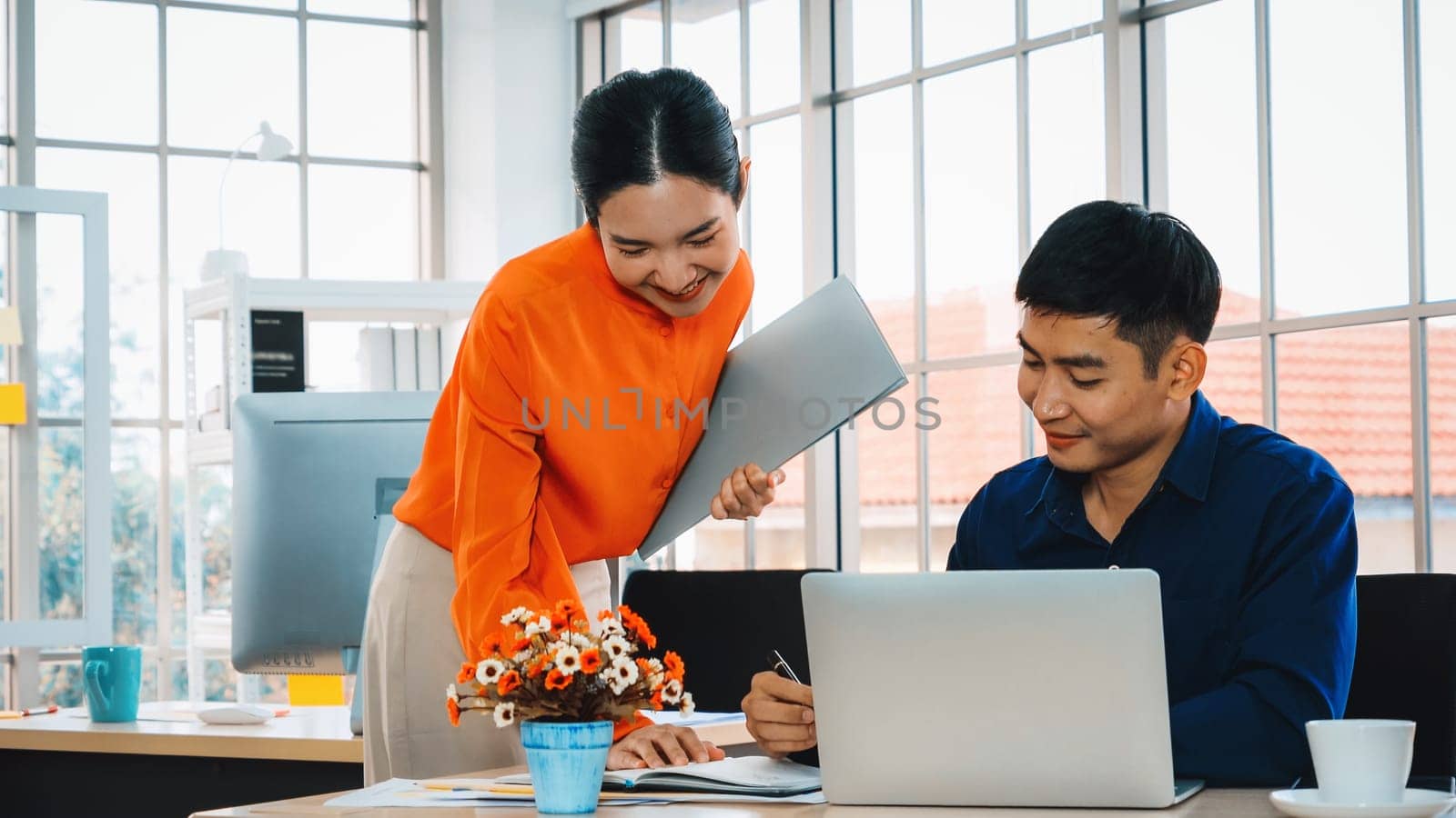 Two business people talk project strategy at office meeting room. Businessman discuss project planning with colleague at modern workplace while having conversation and advice on financial report. Jivy