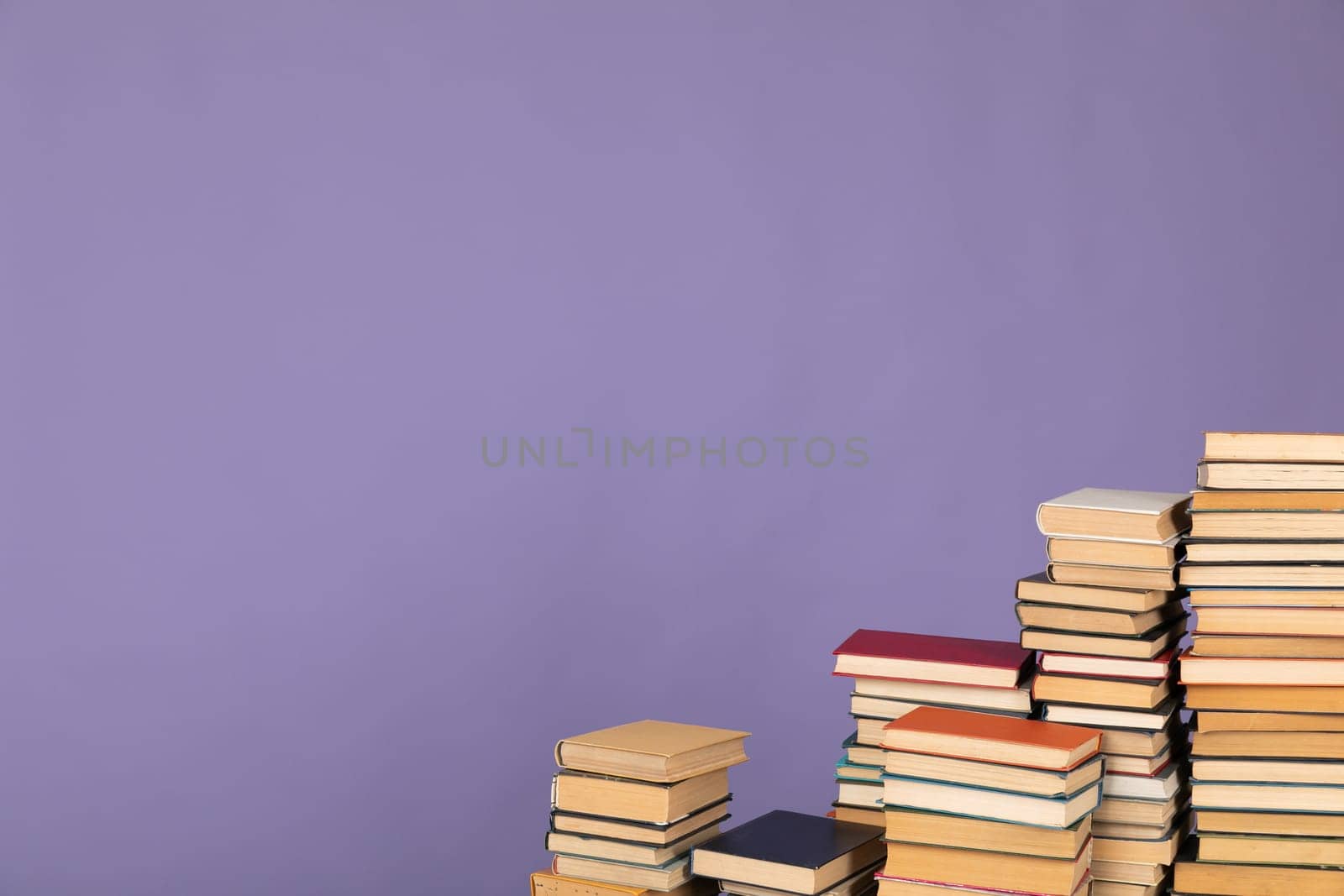 stacks of books scientific literature of knowledge in the library on purple background