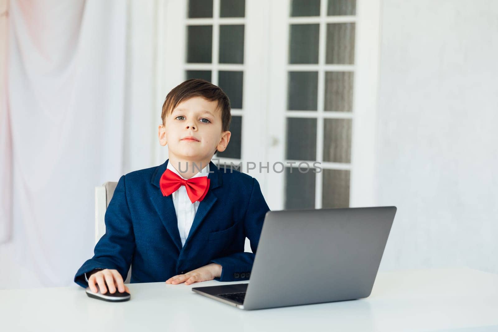 at school in room in the classroom education online boy sitting at a laptop at a table