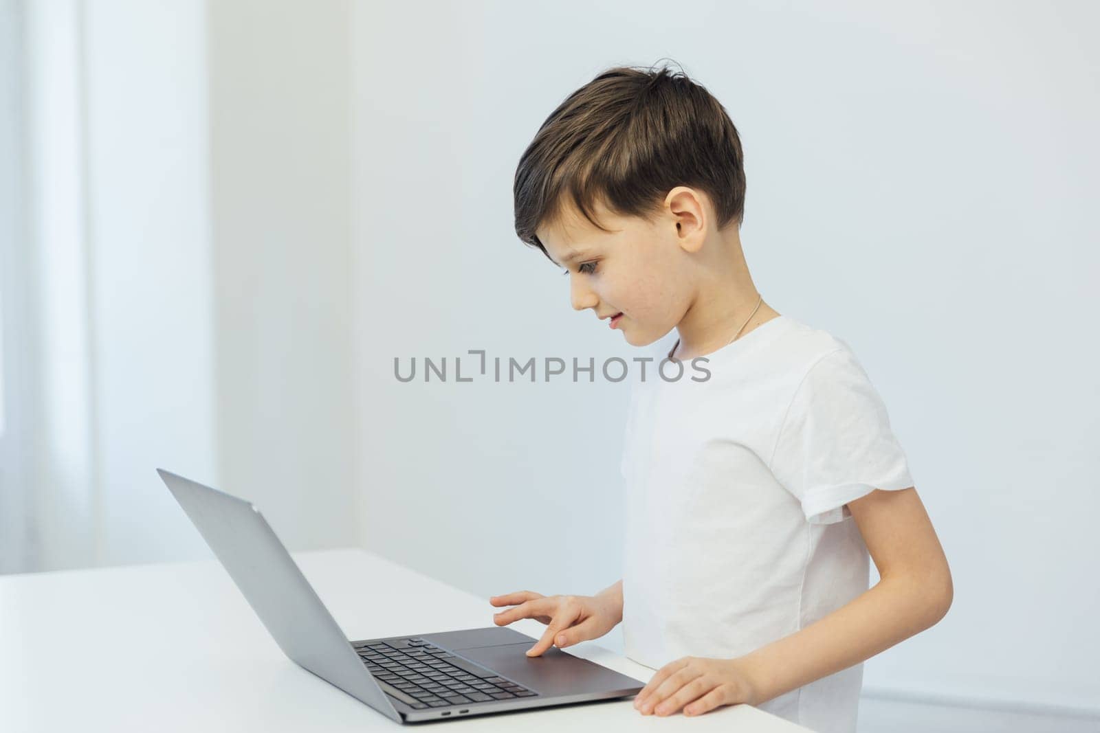 education online school child sitting at a laptop at desk in a room in the classroom