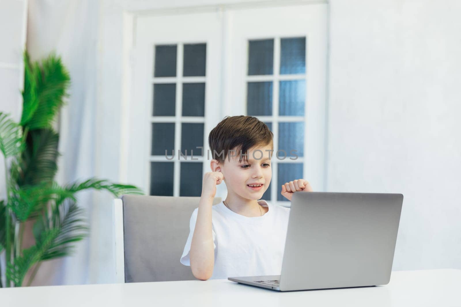 education online school child sitting at a laptop at desk in a room in the classroom