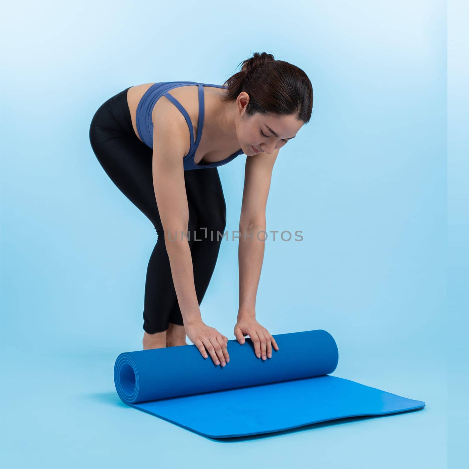 Young attractive asian woman portrait in sportswear with exercising mat. Healthy exercise and workout routine lifestyle concept. Studio shot isolated background. Vigorous