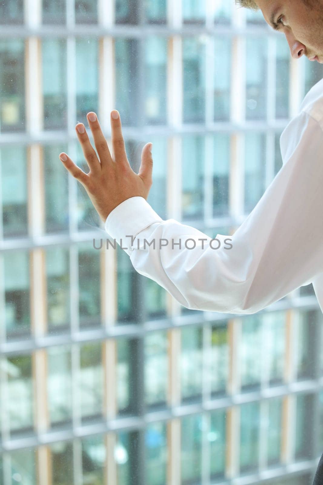 Young caucassian businessman standing against office window