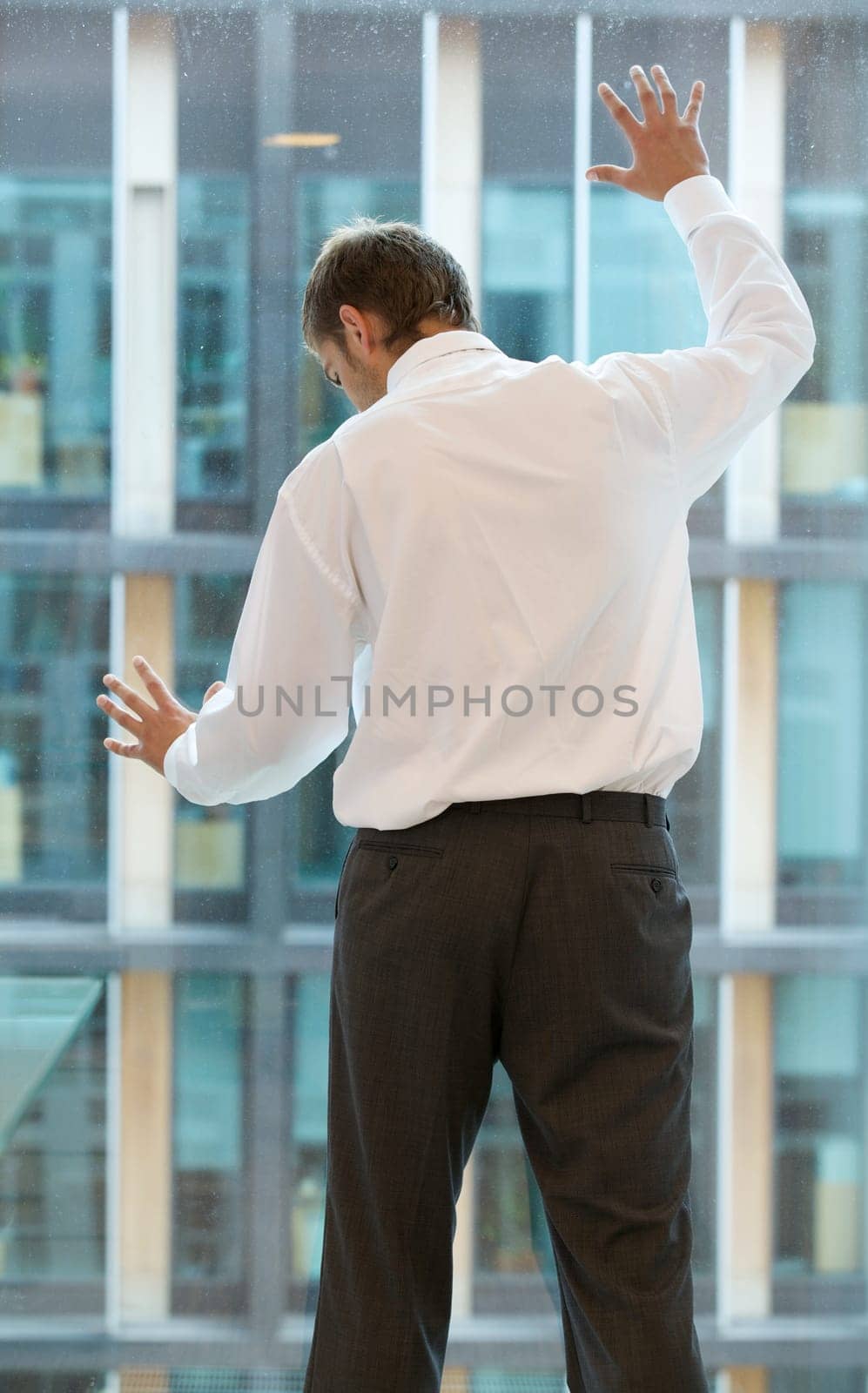 Young caucassian businessman standing against office window