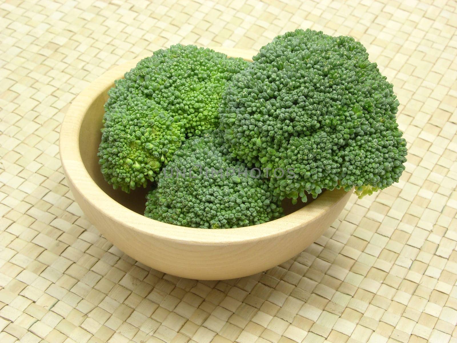 Wooden bowl with broccoli on rattan base