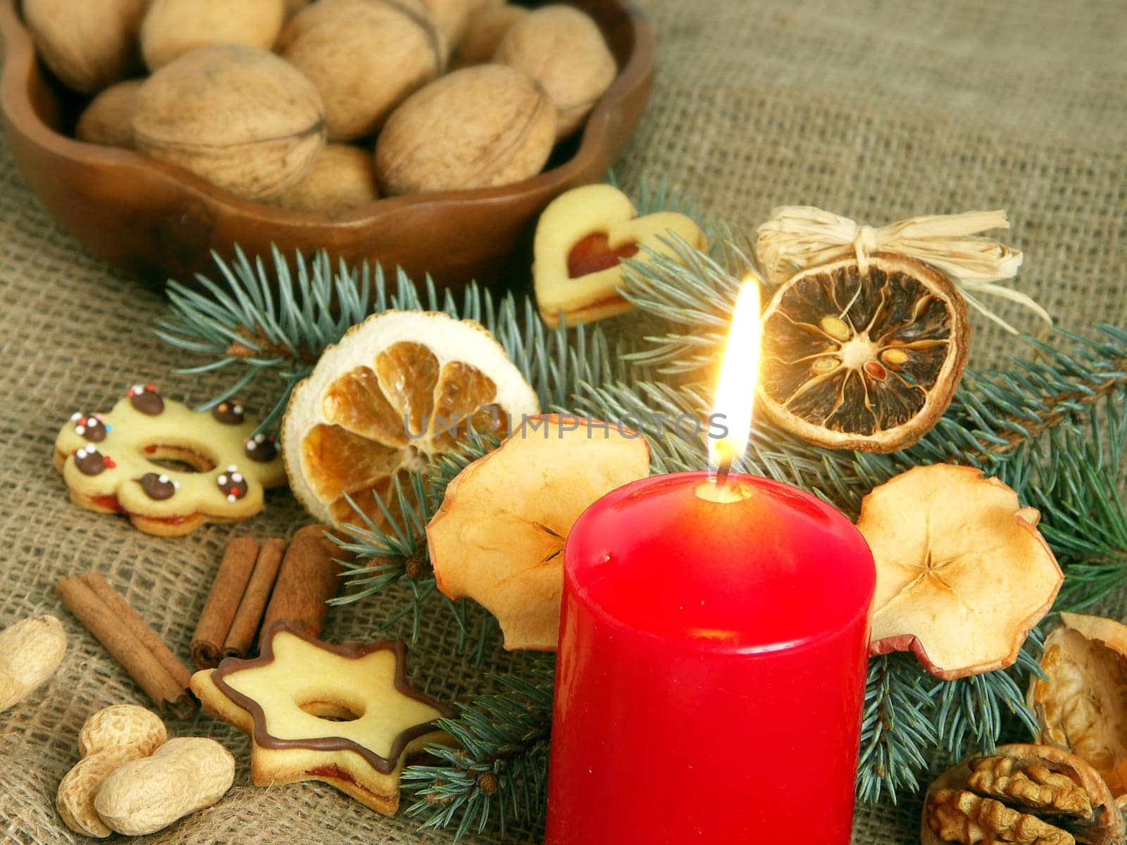 Christmas still life in red candle and dry fruit