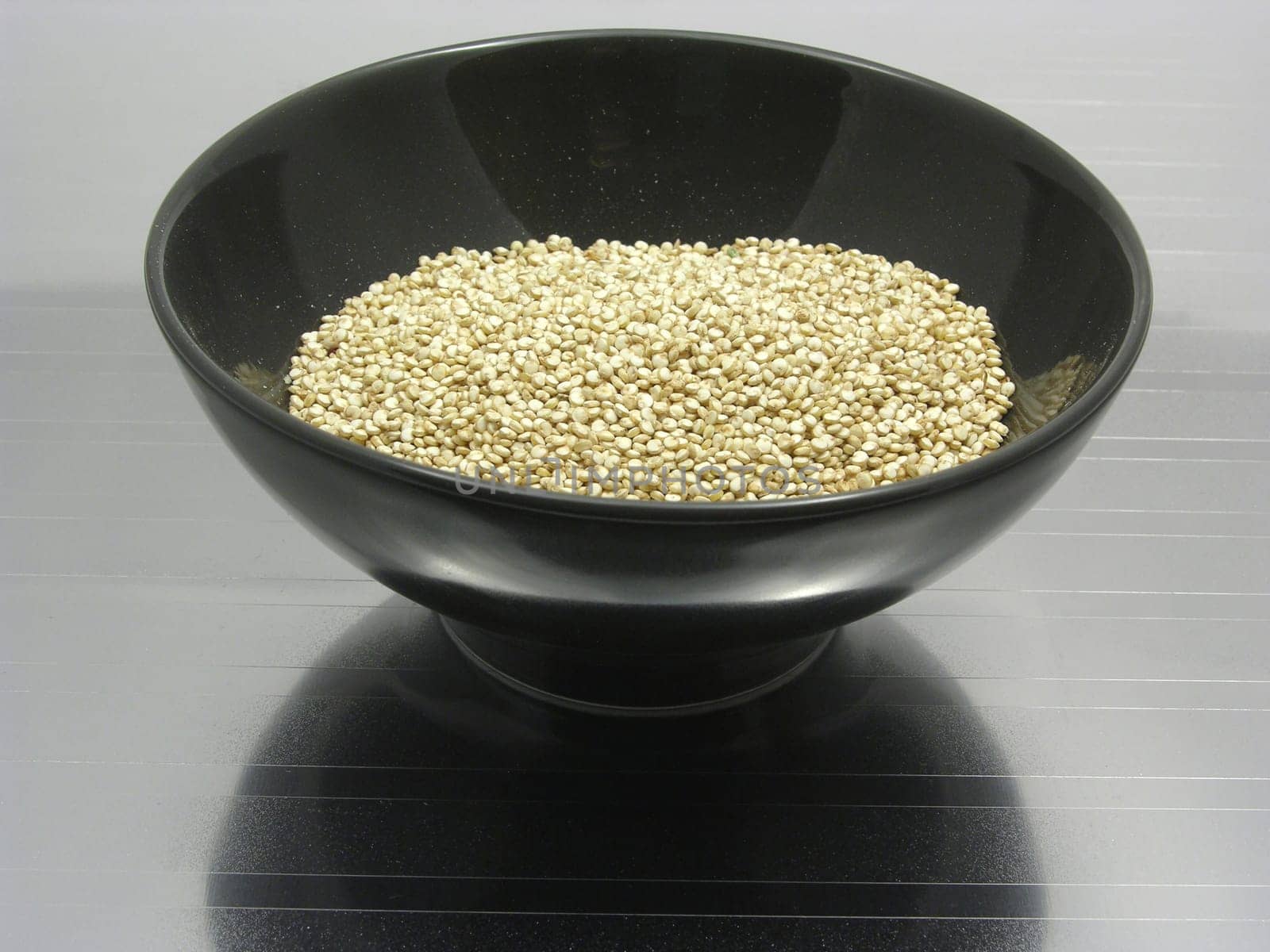 Porcelain bowl with quinoa on a reflective base