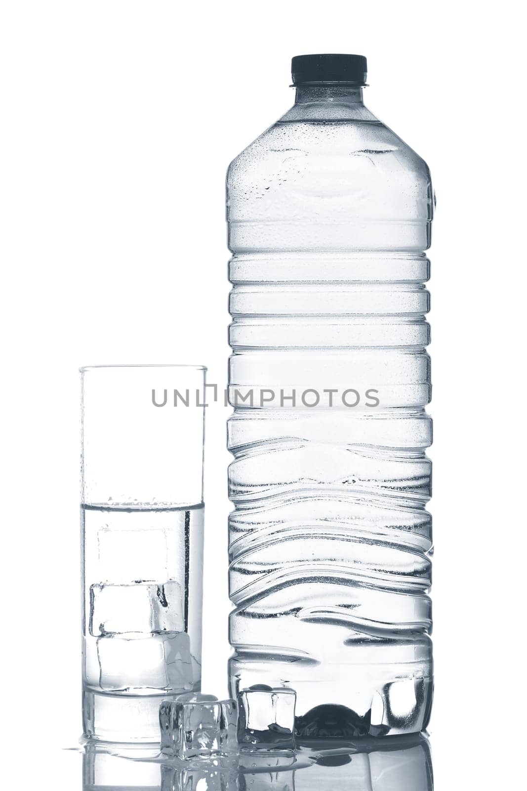 Bottle and glass of mineral water with ice cubes