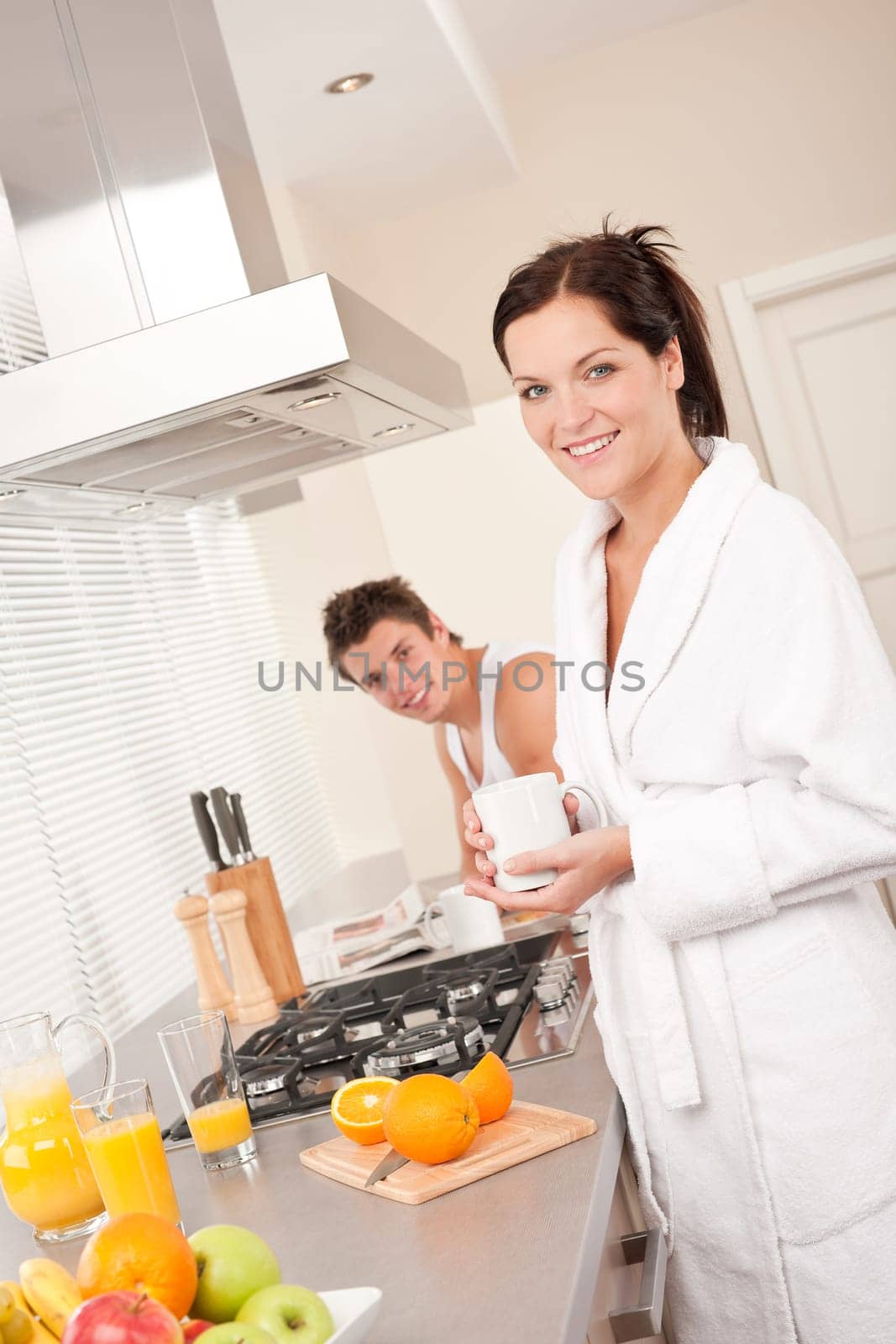 Happy couple having breakfast in the kitchen