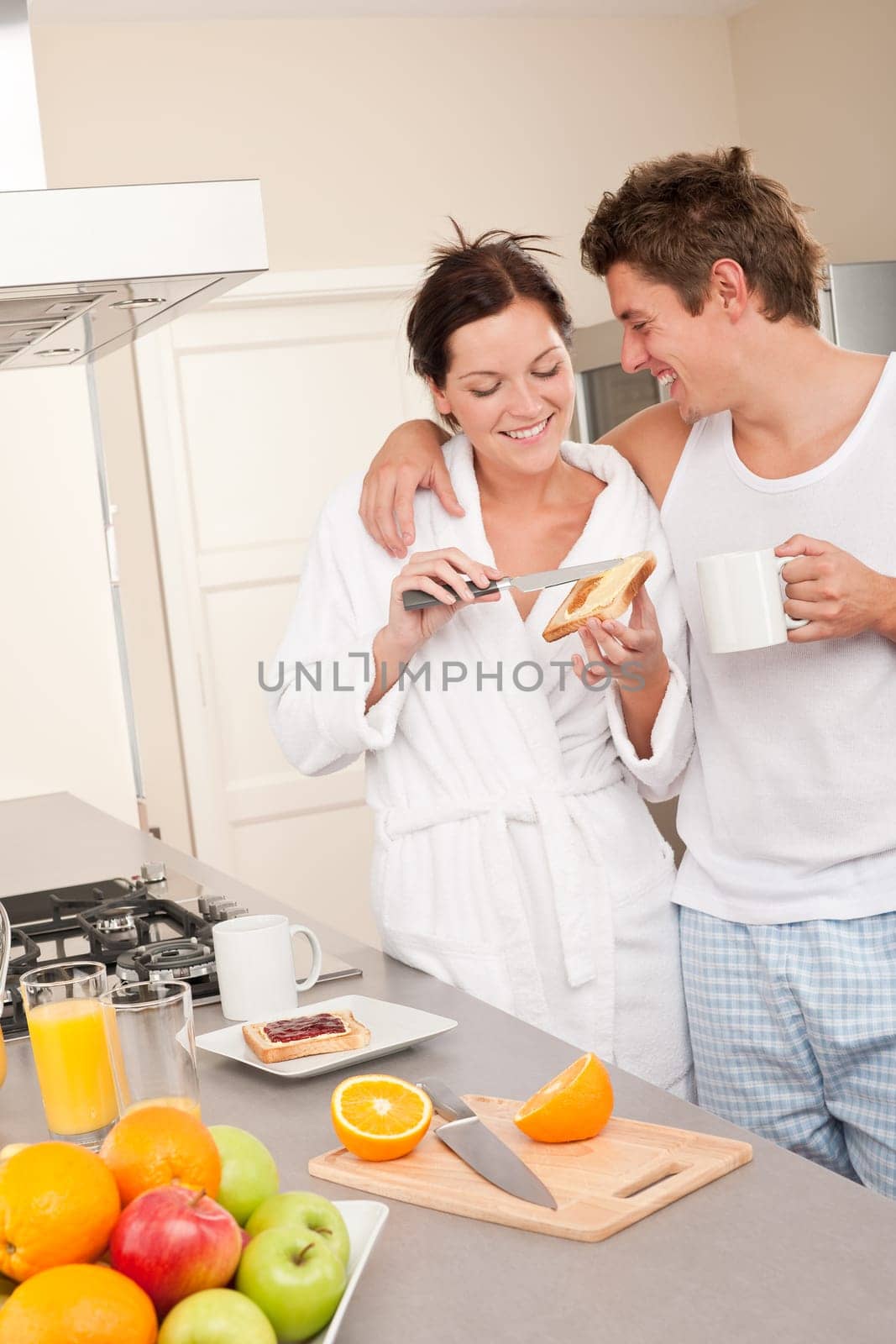 Happy couple having breakfast in the kitchen