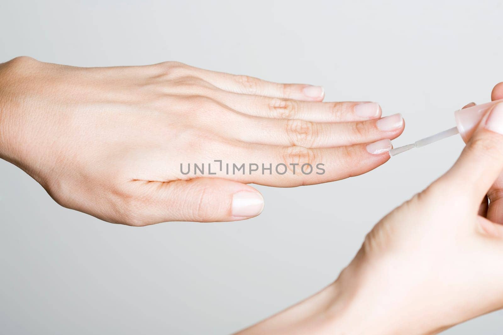Young woman doing manicure