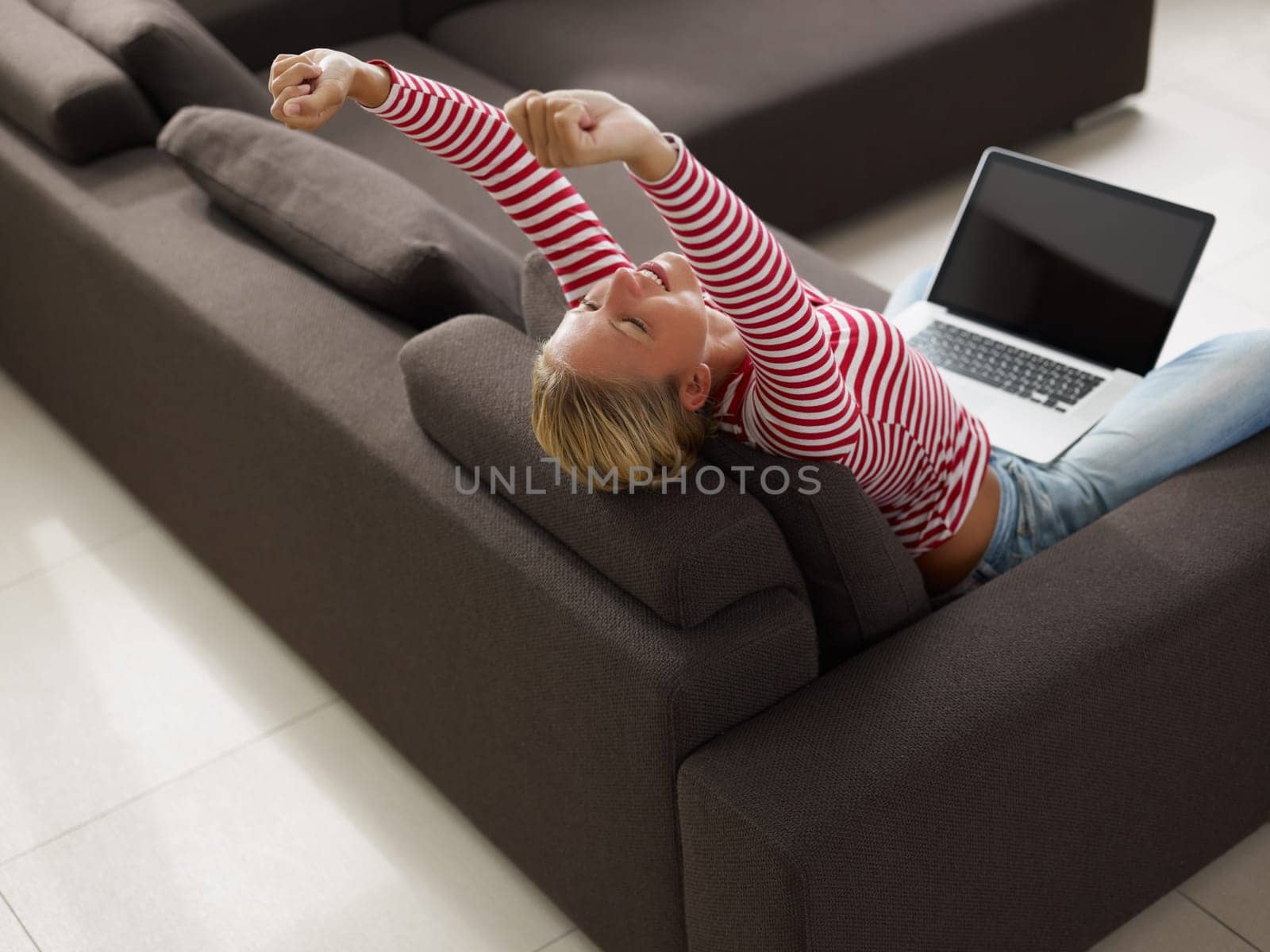 Woman stretching on sofa. High angle view, Copy space