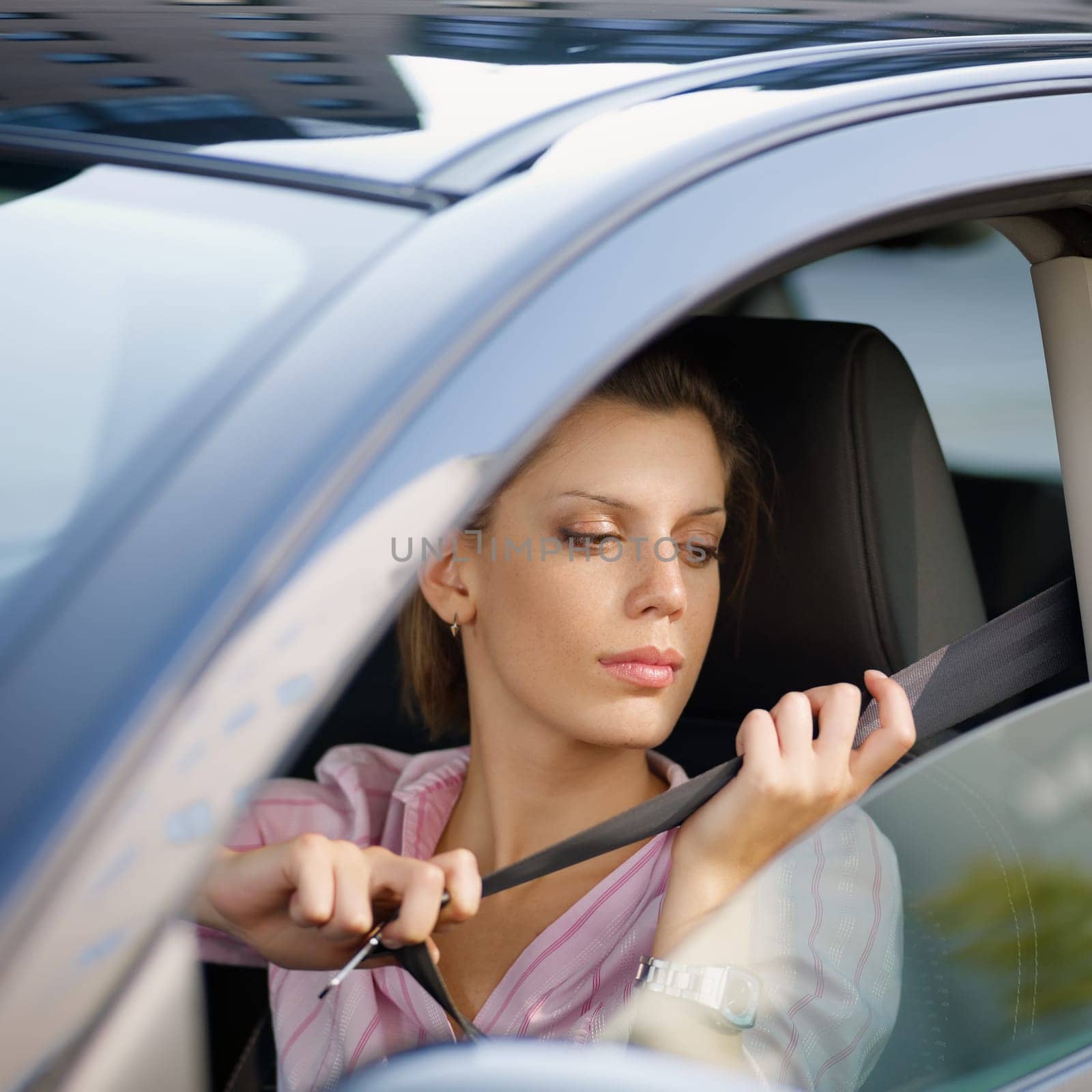 woman in car fastening safety belt
