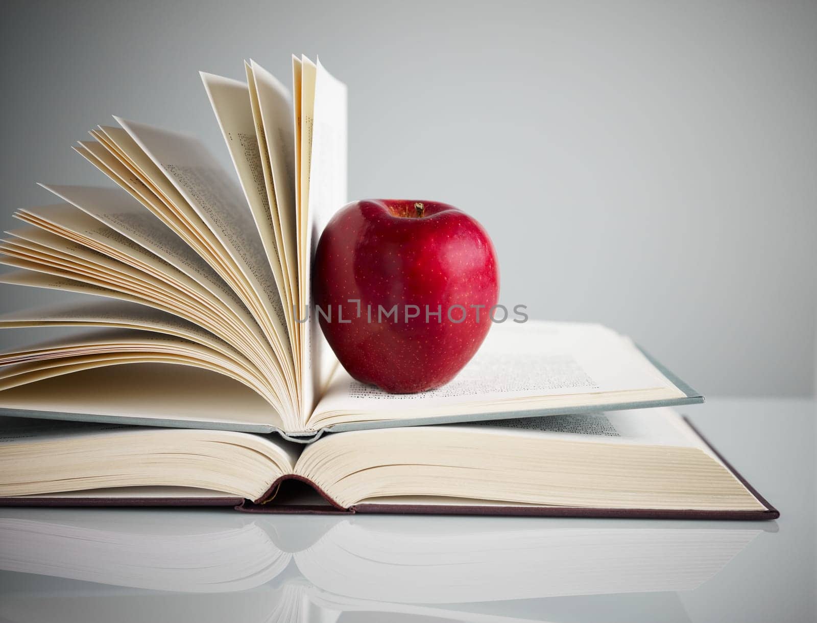 pile of books and red apple on desk. Copy space