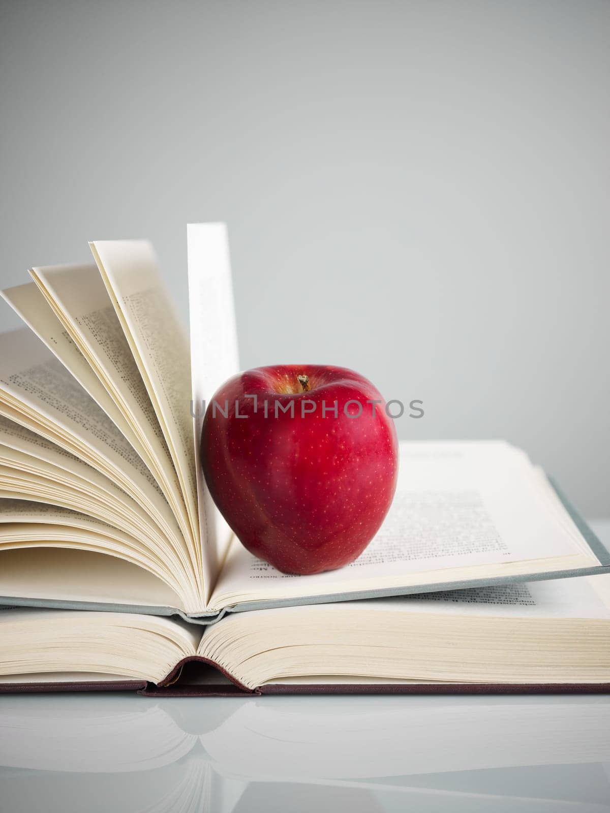 pile of books and red apple on desk. Copy space