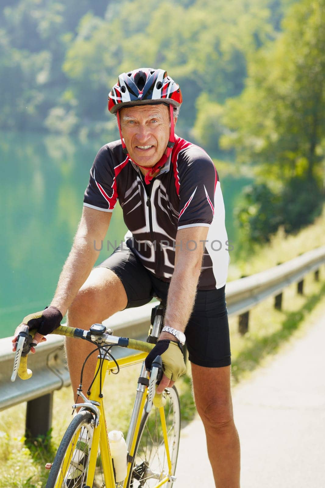 senior man on road bike, looking at camera.