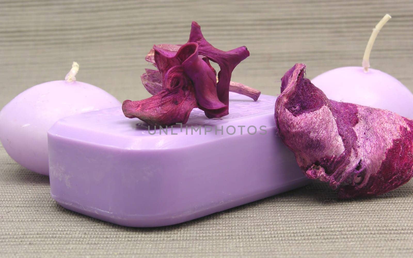 Purple soap with decorative items against gray background