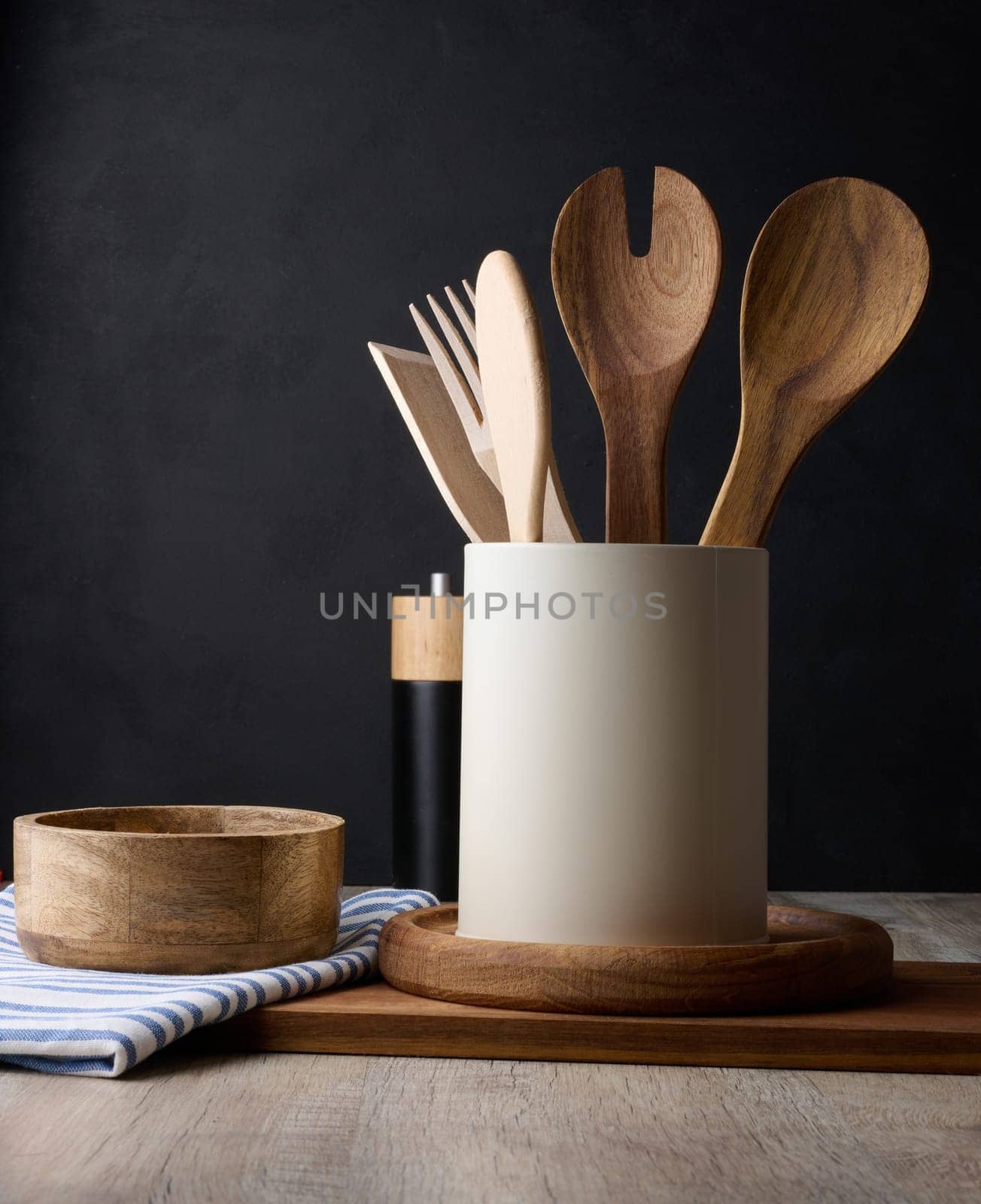 Empty bowl and wooden spoons on a table, black background