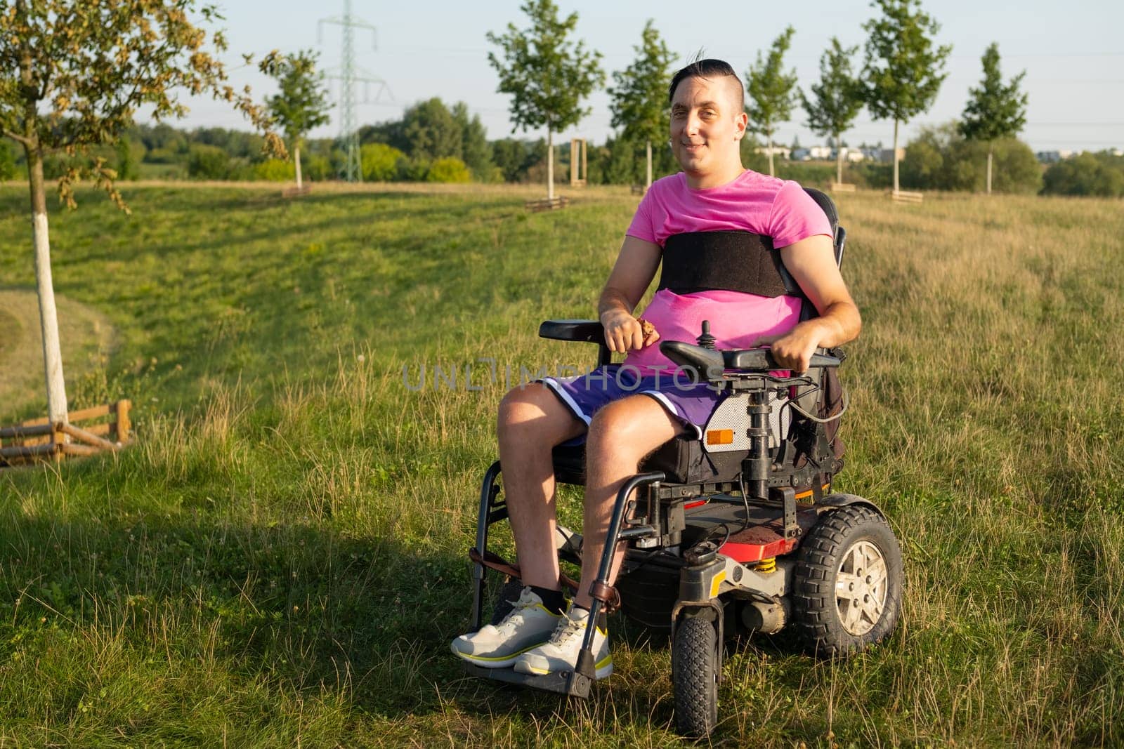 Handsome disabled man sitting in a wheelchair at the park.