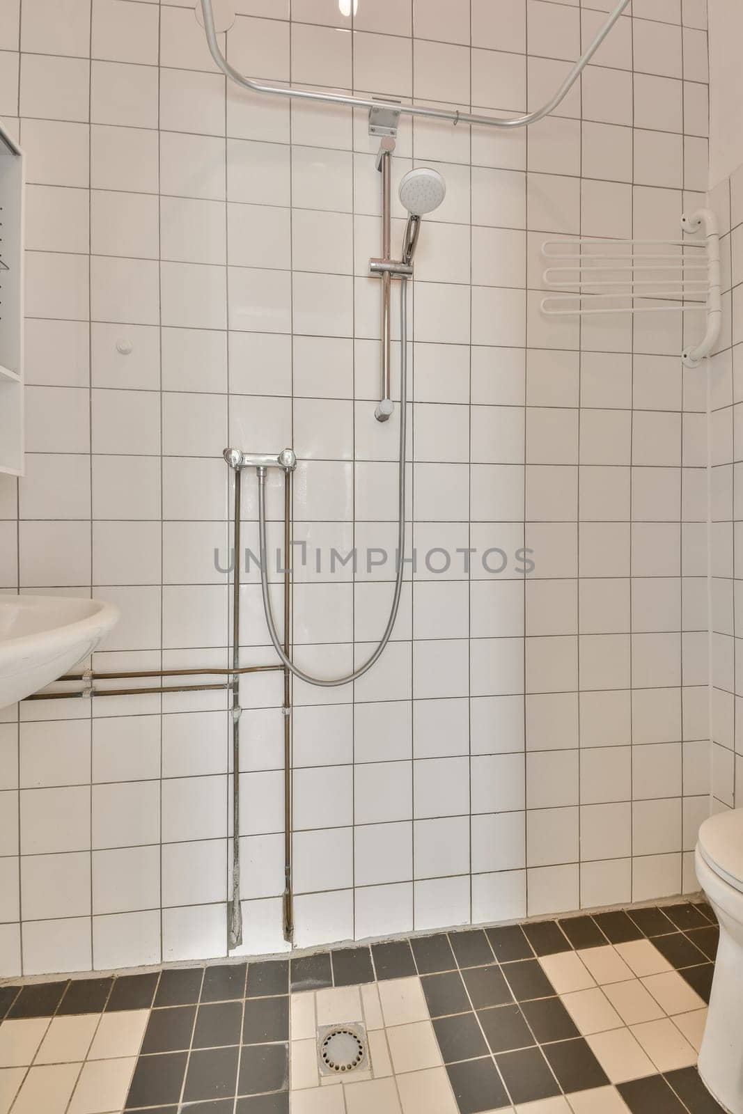 a modern bathroom with black and white tiles on the floor, toilet and shower stall in the background is tiled