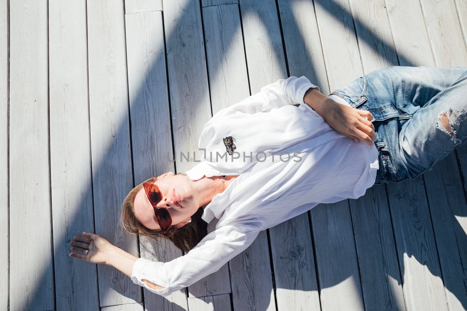 woman lies on a wooden floor on the street